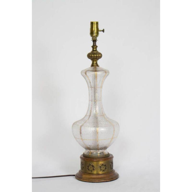 Glass 70’s Table Lamp with Gold Accents and Wooden Base. Glass has a glue chip texture

Material: Art Glass,Wood
Style: Mid-Century Modern,Hollywood Regency
Place of Origin: Italy
Period made: Mid 20th Century

Dimensions: 7 × 7 × 24
