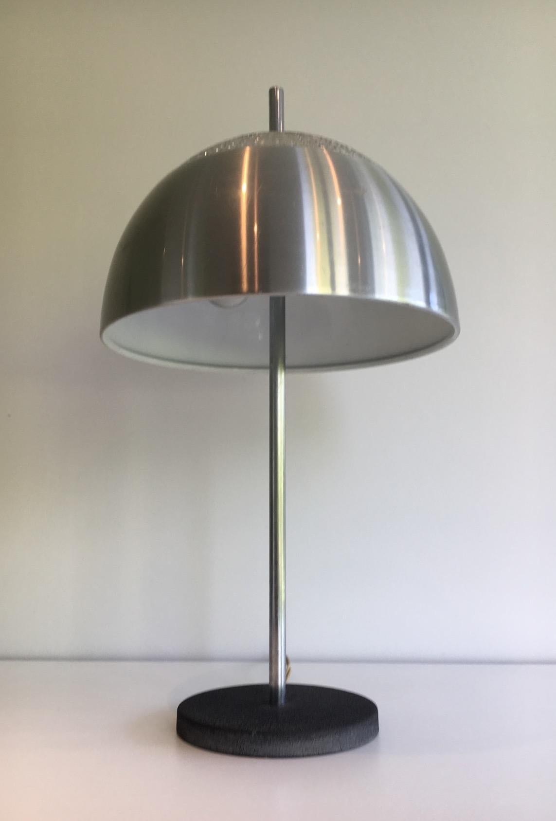 This table lamp is made of chrome, black lacquered cast iron and glass. This is a French work, circa 1970.