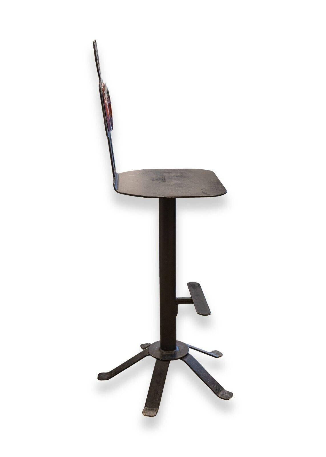 A glass and metal chair signed and dated by artist Drew Smith. This unique accent chair is artfully constructed with a black metal featuring a sculpted figure back, six surrounding legs, and a foot rest midway down the center column. In the center