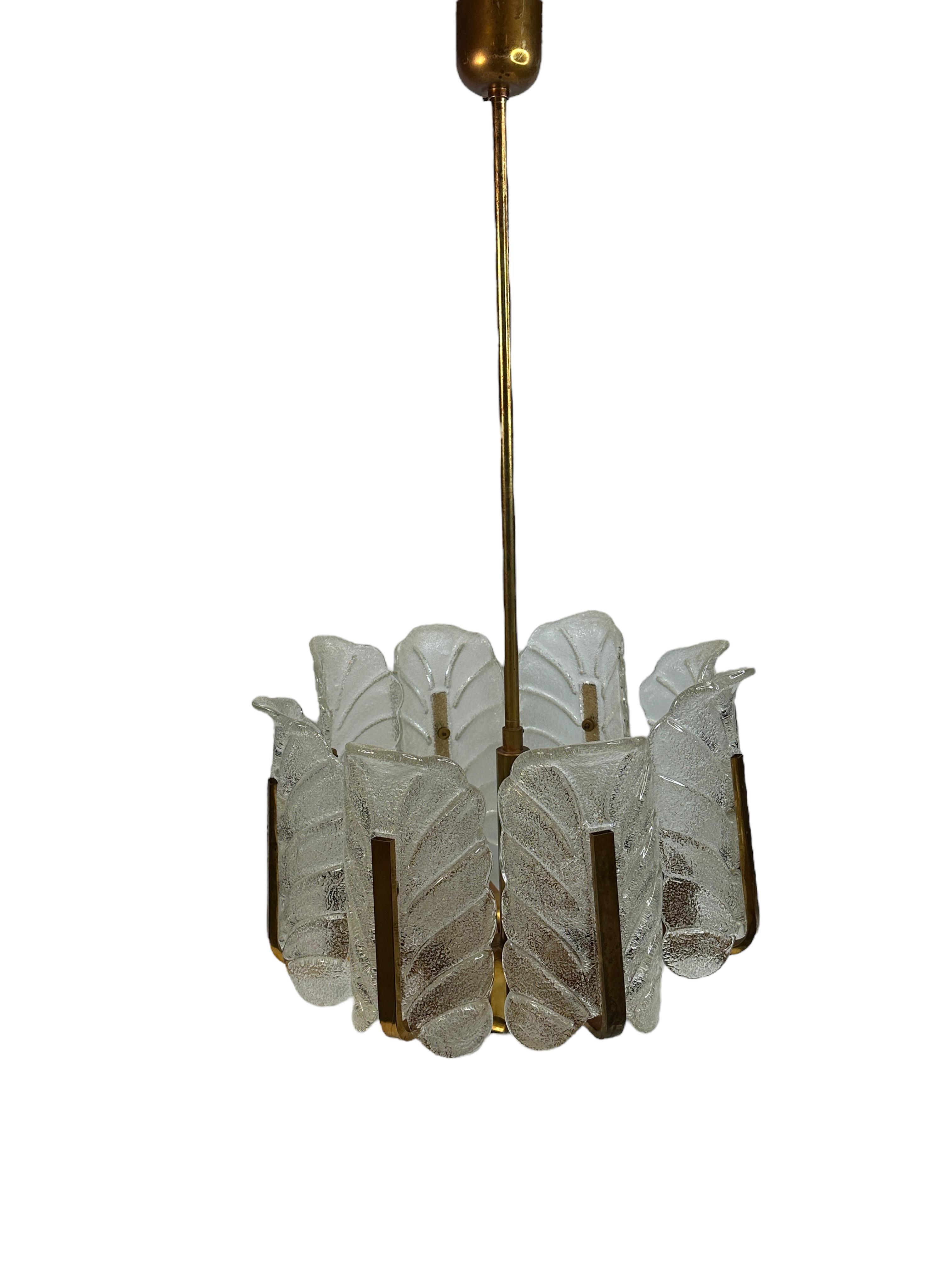 Large glass and brass chandelier by Carl Fagerlund for Orrefors. This large brass chandelier consists of 8 arms has 8 light sources. Each arm contains a Murano frosted glass acanthus leaf shade. Offered midcentury chandelier has original wire and
