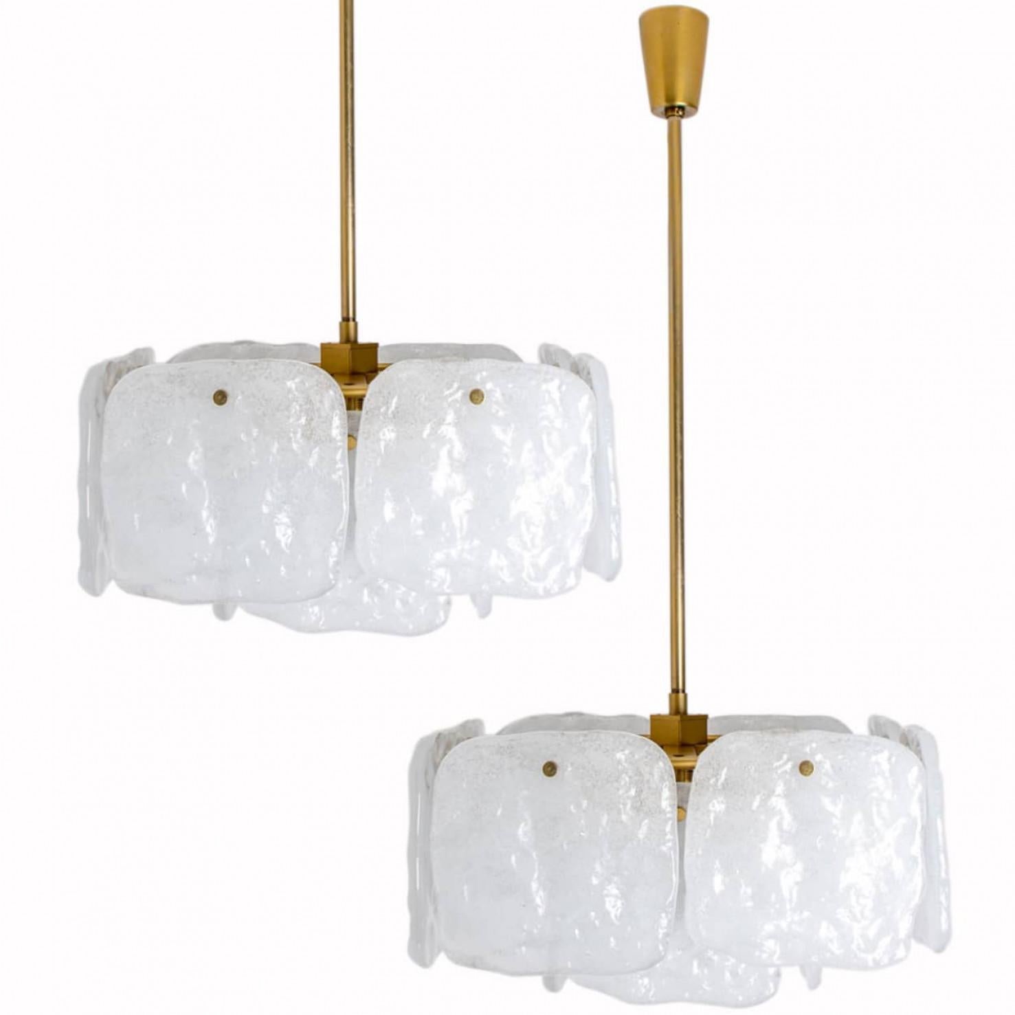 Un magnifique lustre conçu par J.T Kalmar, fabriqué par Kalmar Franken, en Autriche, dans les années 1960.
Design/One haut de gamme et fait main du 20e siècle. Les grands carrés d'abat-jour en verre texturé blanc et opaque offrent une lumière