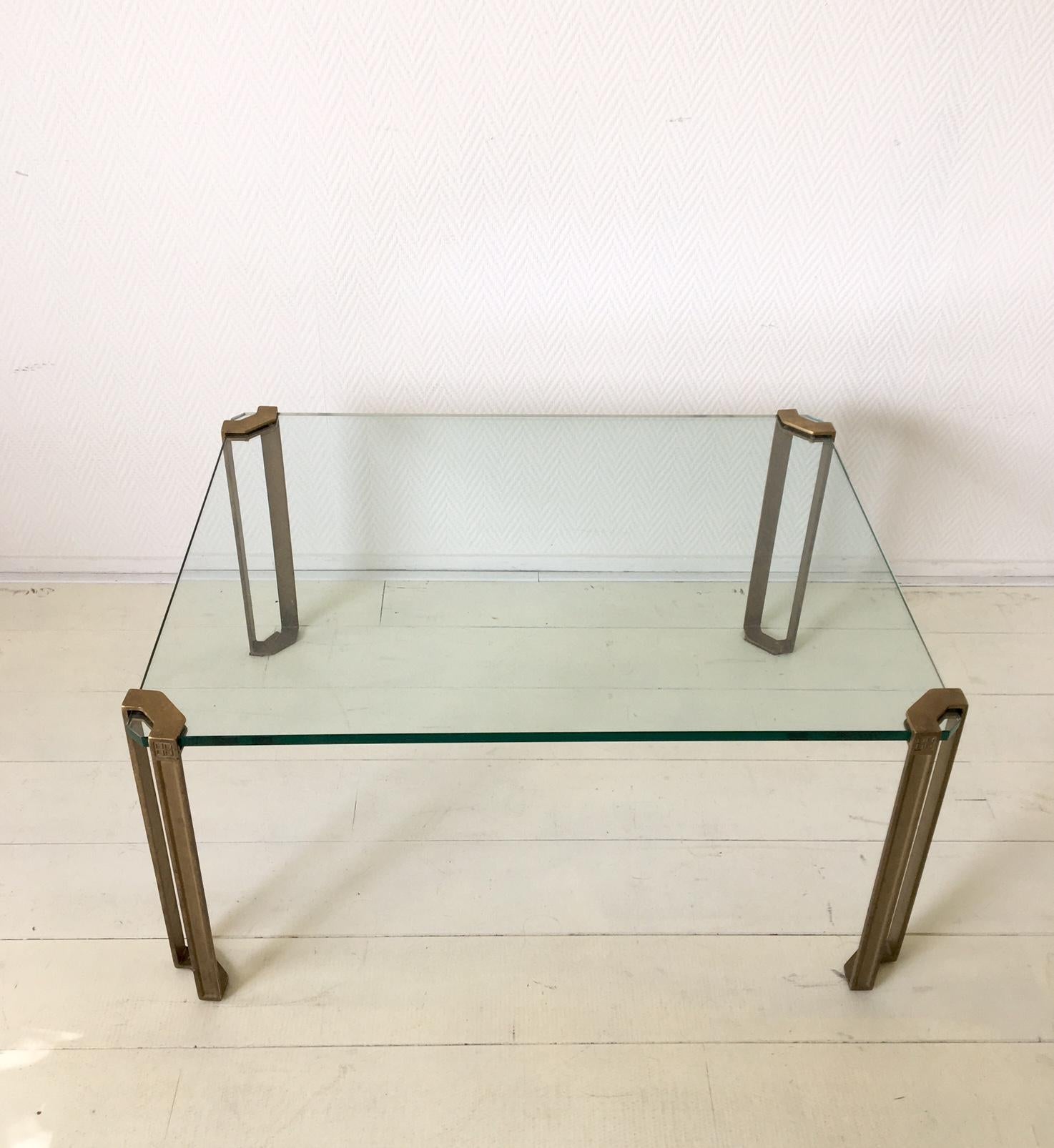 This coffee table was manufactured by Peter Ghyczy in the Netherlands, circa 1970s. It features four brass legs, and a thick glass surface. The piece remains in wonderful condition with normal signs of age and use. Not in production anymore. Easy