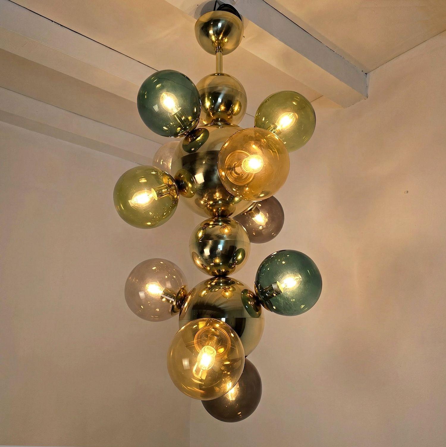 Grande lampadario o lampada a sospensione in ottone e sfere di vetro del Mid Century Modern, Italia, circa anni 2000.
Il lampadario è composto da sfere di vetro colorate, sfere e stelo in ottone lucido.
Le sfere di vetro sono di diversi colori