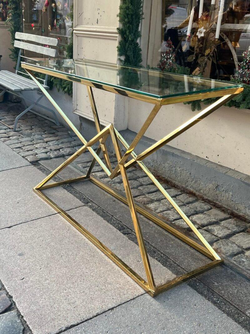 Une table console élégante, accrocheuse et étonnante du milieu du siècle, en provenance de France. Une magnifique base élégante et angulaire, et un plateau en verre épais de qualité.