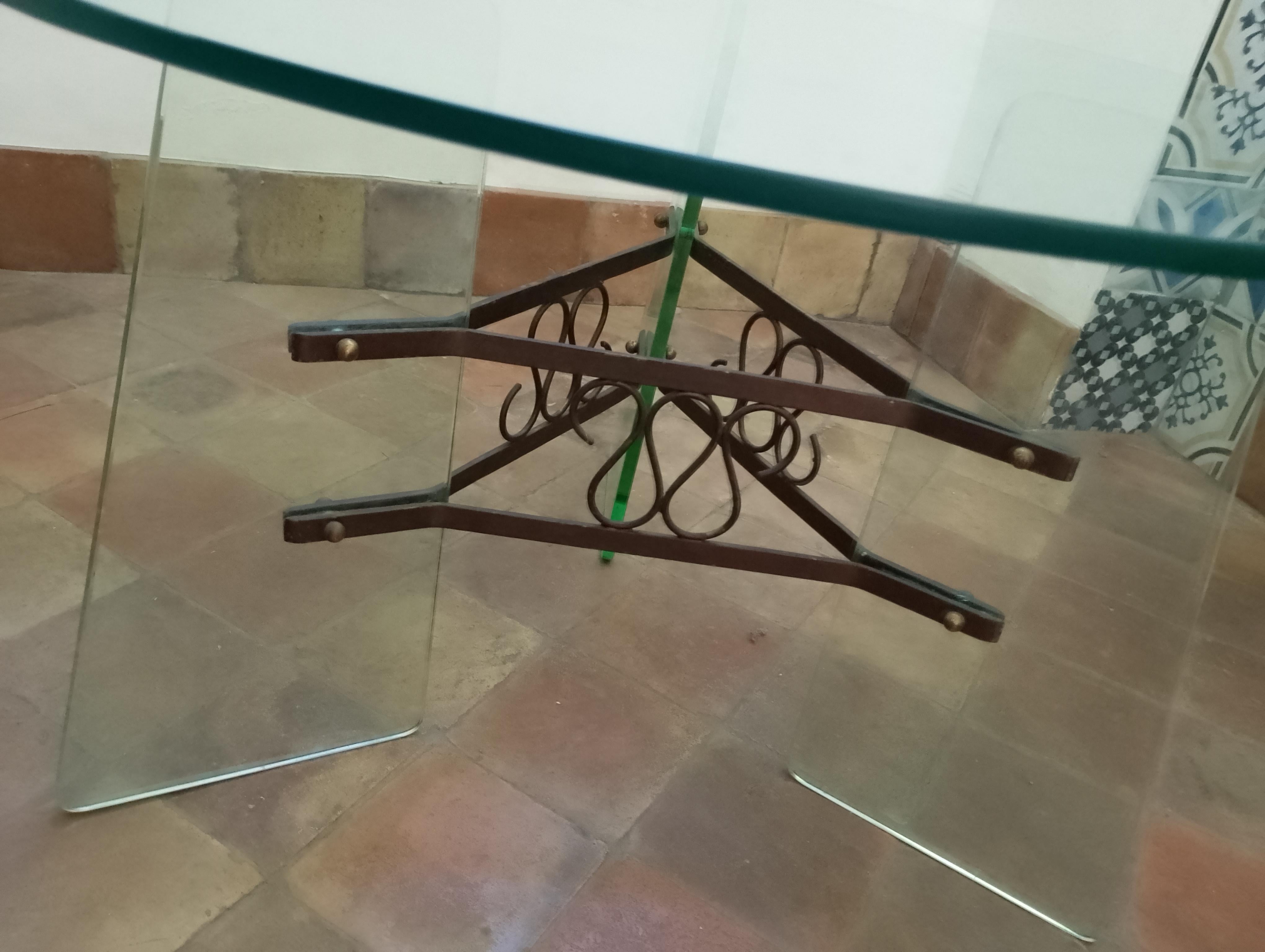 Table en verre et laiton fabriquée en Italie vers 1940
Rare table d'appoint en cristal comprenant trois pieds en cristal très épais, un système de montage central en laiton avec des accents décoratifs tourbillonnants en laiton et un plateau rond en