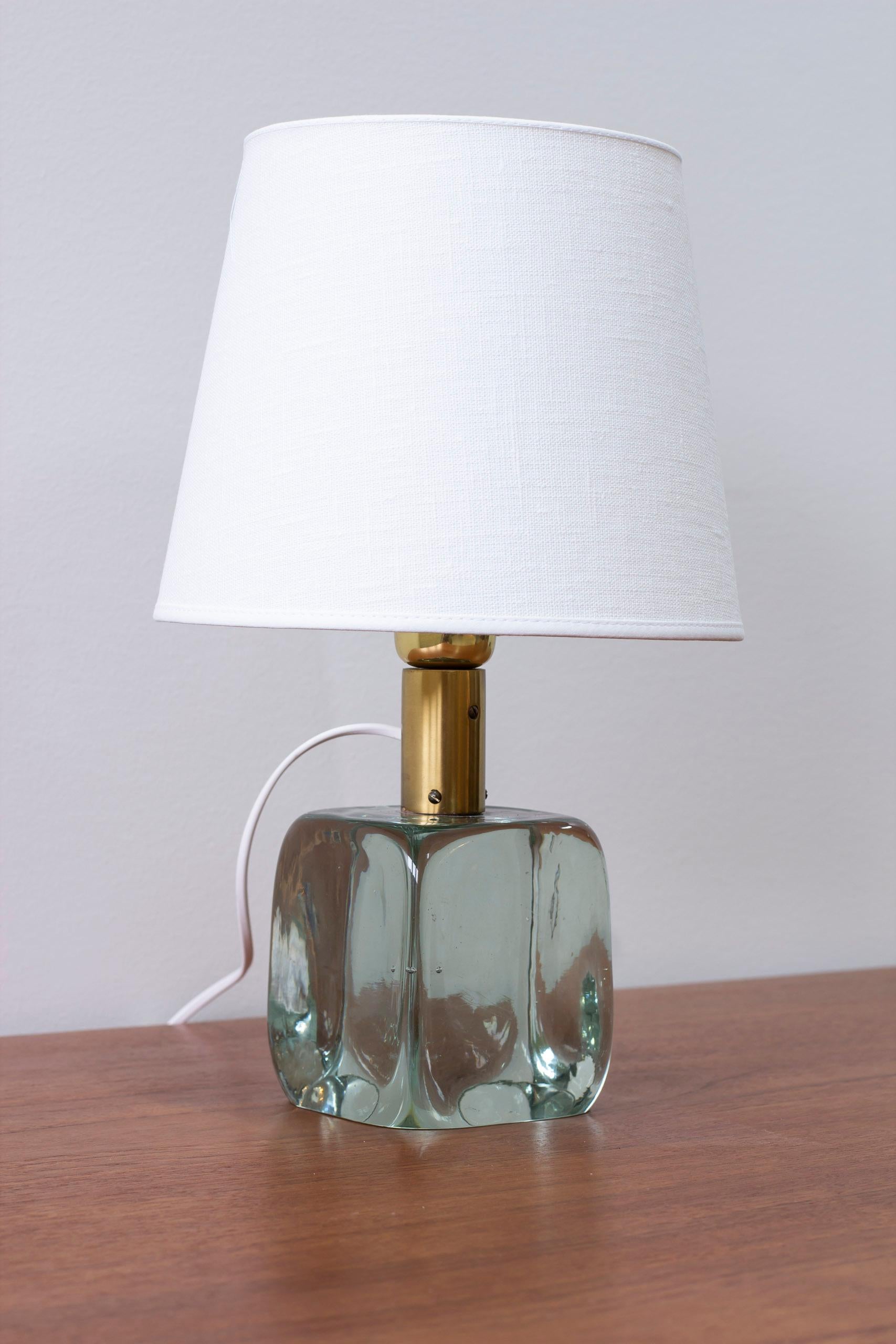 Table lamp model 1819 designed by Josef Frank. Produced in Sweden by Svenskt Tenn, the glass mold blown by Reijmyre. Thick mold blown clear glass and brass. Light switch on the lamp holder in working order. Very good vintage condition with few signs