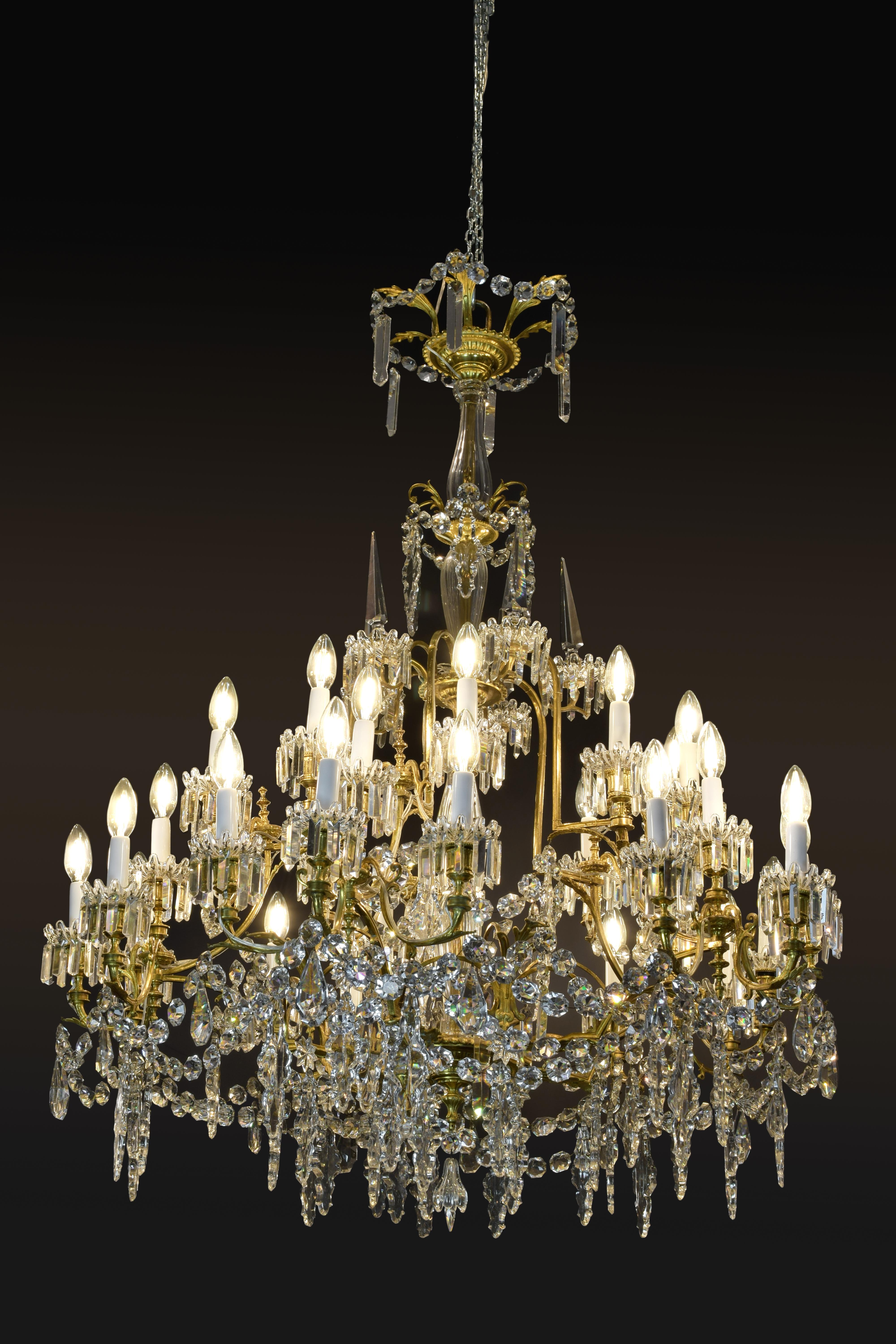 Thirty lights chandelier. Bronze and glass, late 19th century.
It is necessary to emphasize the variety of forms and the quality of the colorless glass. The profiles of some beads (tears, polygons, pinnacles) are found both in Bohemian and other