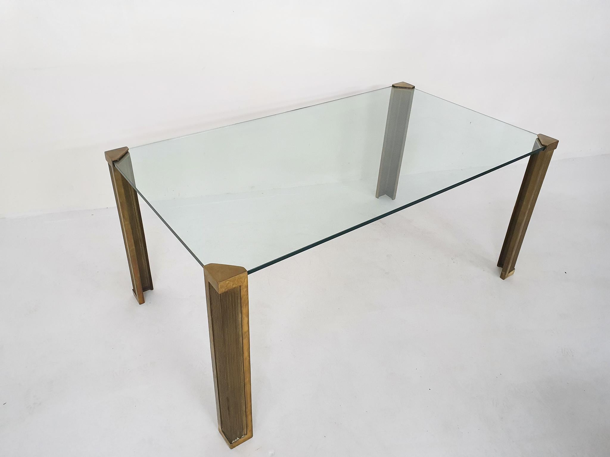 Large T14 glass dining table with four bronze legs. Marked by Ghyczy design.
There is a small chip fromt the corner of the glass, but this is hidden in the leg, so not visible when assembled.

Architect and designer Peter Ghyczy, born in Hungary
