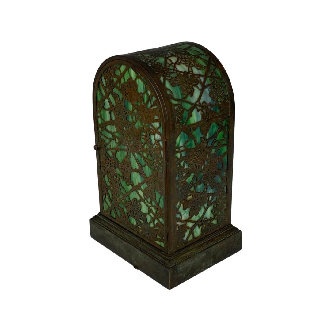 An Art Deco table clock in bronze with green glass details. Signed and numbered by Tiffany Studios.
Made in USA.