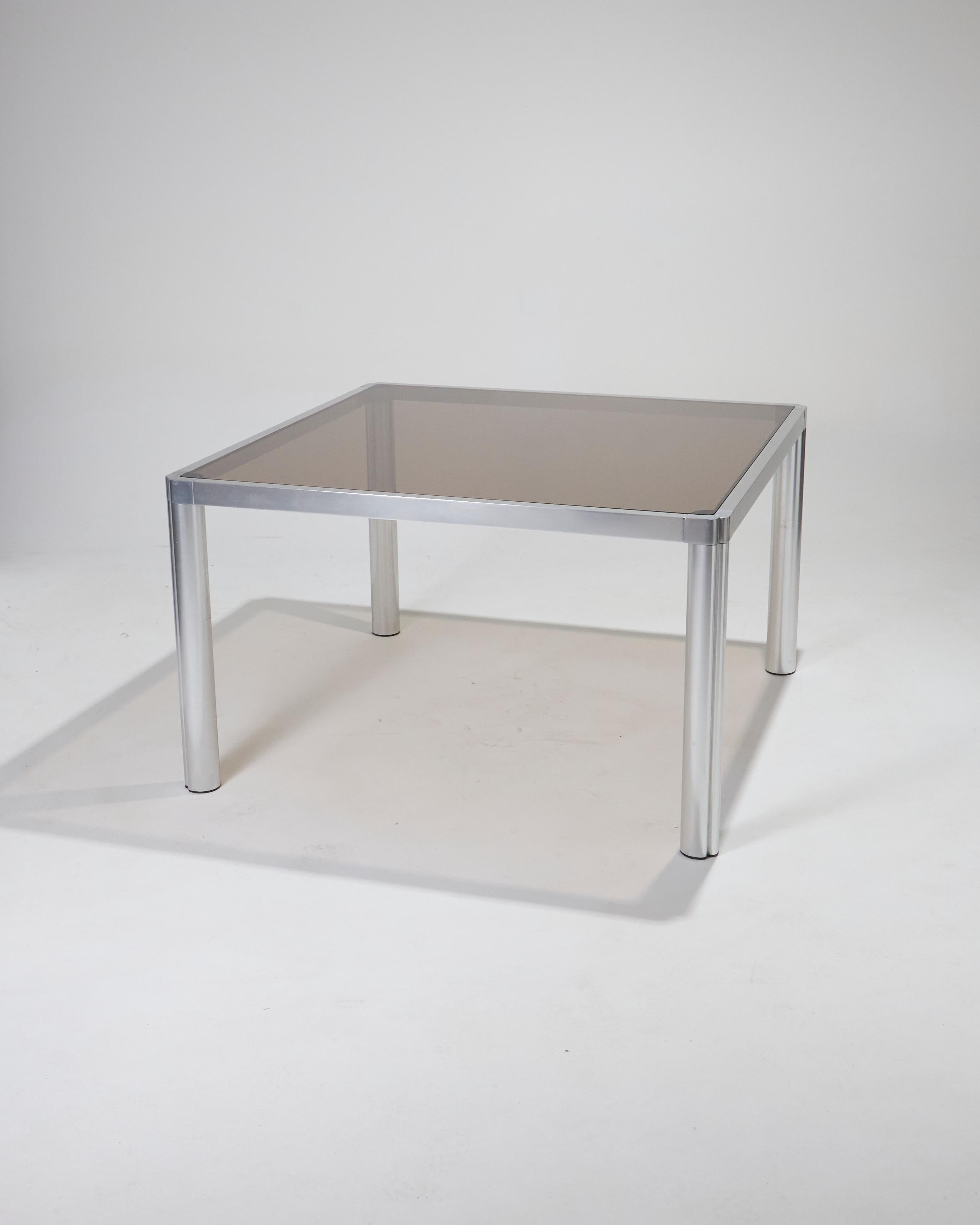 Table de salle à manger carrée avec plateau en verre fumé et cadre en aluminium épais, alliant à la fois modernité et sophistication. Le plateau en verre fumé offre une transparence subtile, créant une sensation d'espace tout en soulignant la
