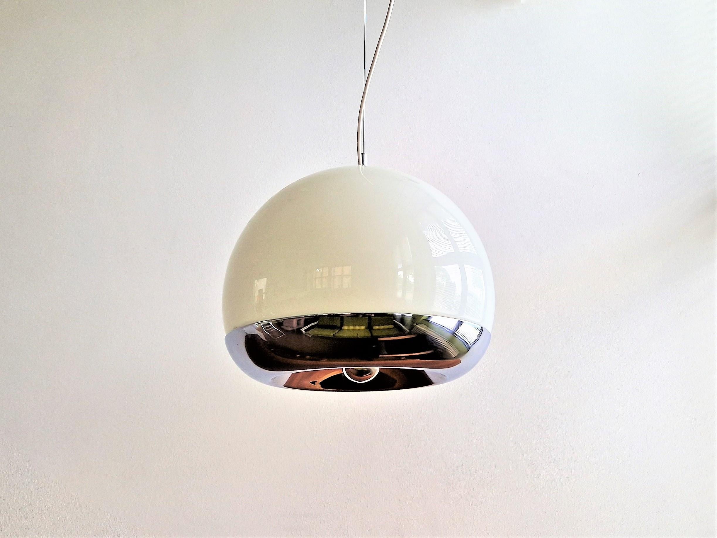 Cette magnifique lampe suspendue a été produite à partir d'un projet des architectes De Martini, Falconi & Fois pour Reggiani. Il se compose d'un bol en verre opalin blanc qui peut contenir 2 ampoules, avec une partie inférieure en métal chromé qui