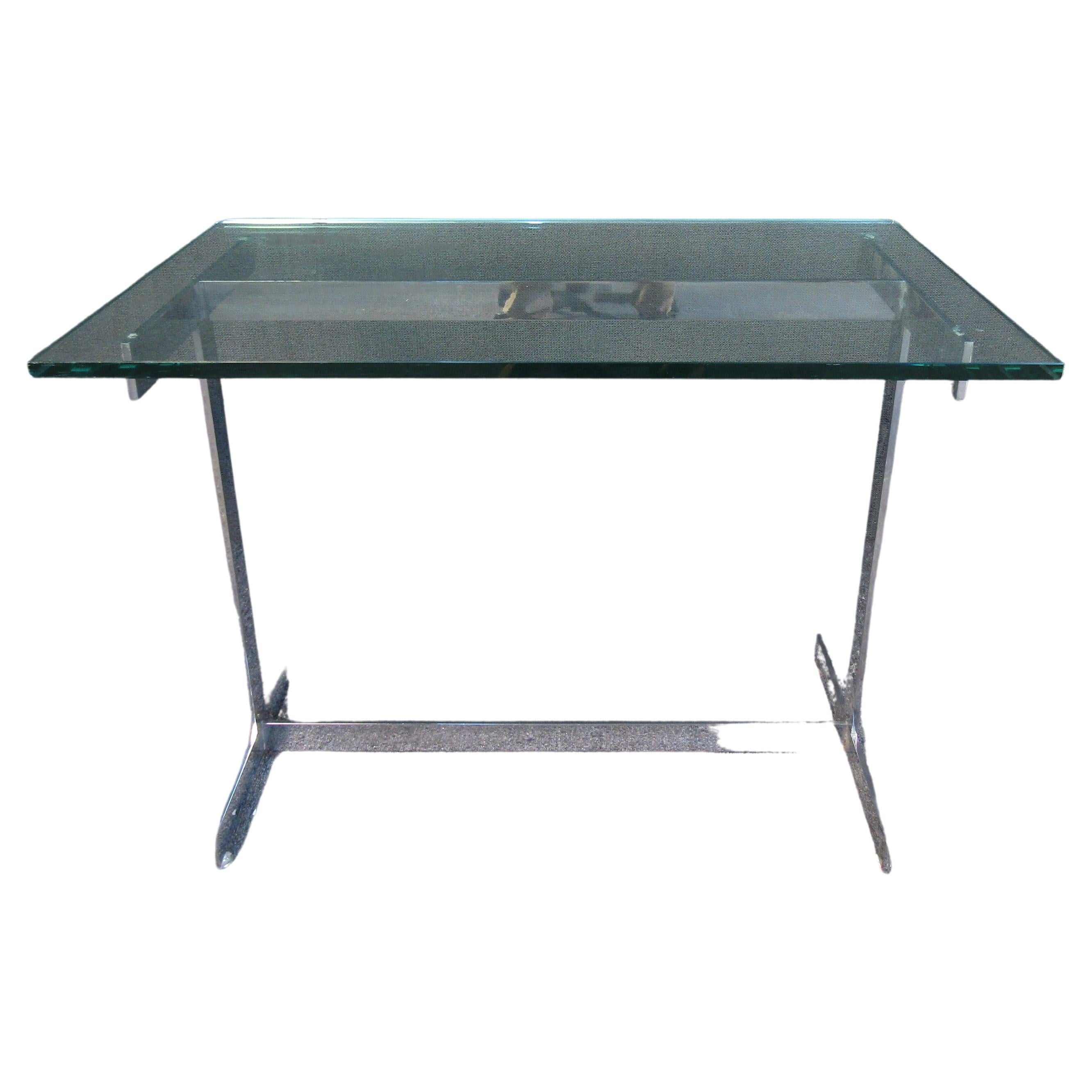This elegant chrome and glass side table offers Mid-Century Modern style in the style of Milo Baughman. A thick glass top adds a touch of quality consistent with Mid-Century craftsmanship. Please confirm item location with seller (NY/NJ).