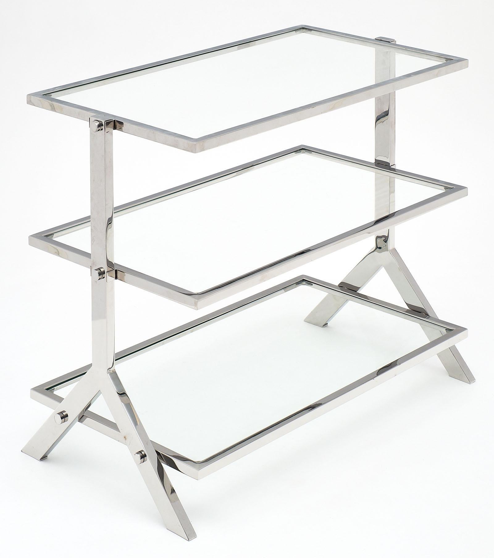 A sleek French chrome and glass console or side table. We loved the architectural lines and balance of this piece. It has three glass shelves inserted in the chromed steel frame.