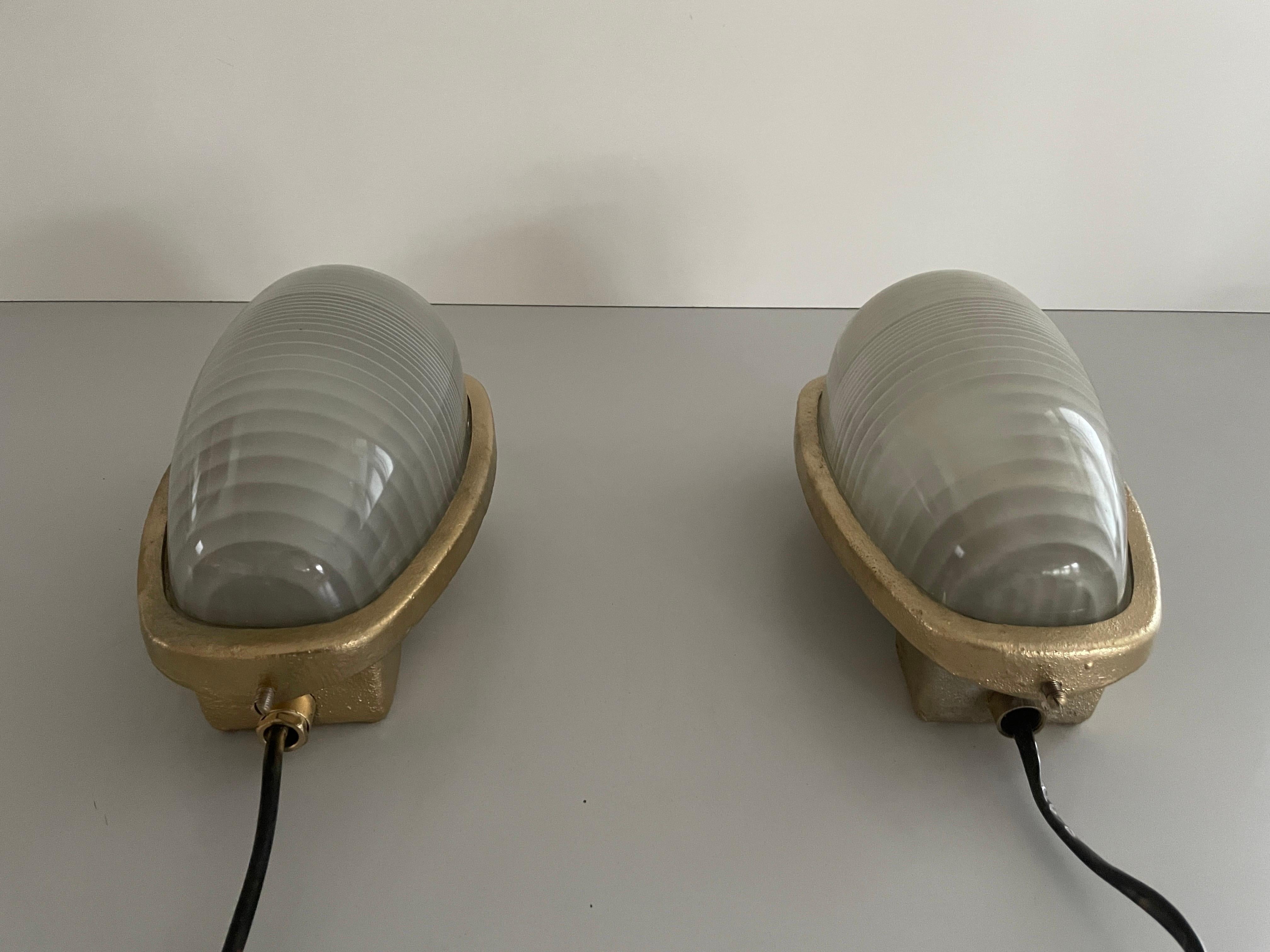 Glass and Gold Coated Brass Pair of Industrial Sconces by Lambda, 1960s, Italy

Very elegant and Minimalist wall lamps.
These are very heavy outdoor lamps 
Single lamp weight: 4,8 kg

Lamps are in excellent condition.

These lamps works with E27