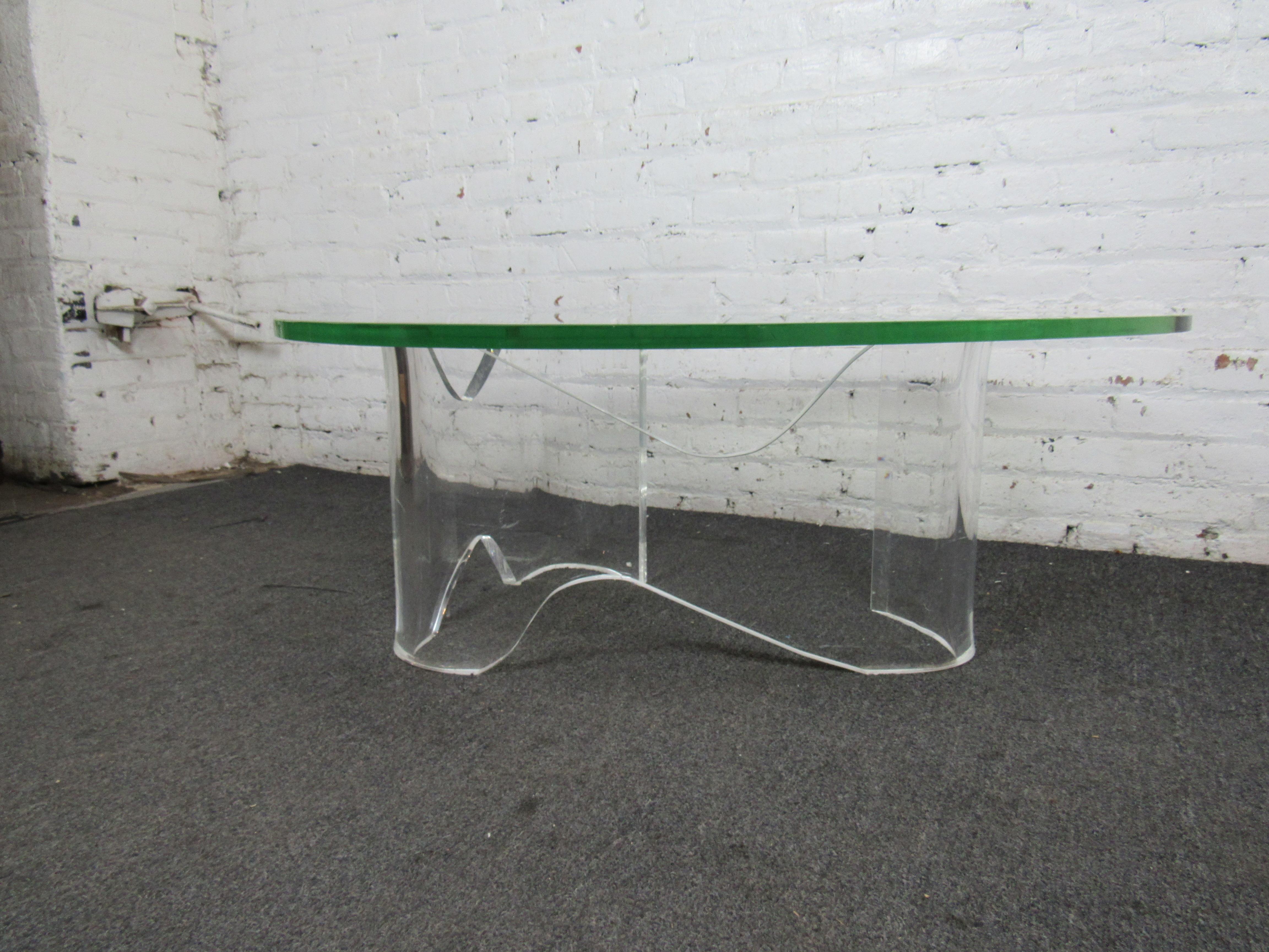 A curving lucite base and thick glass top make this vintage coffee table unique and stylish. Please confirm item location with seller (NY/NJ).