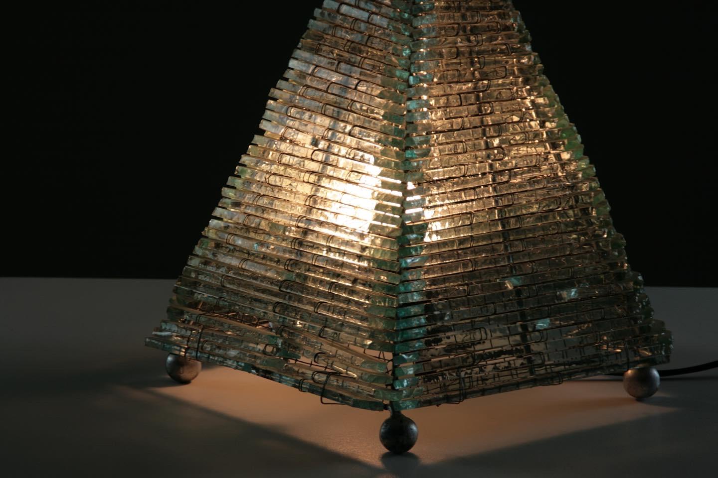 Table lamp in the shape of a pyramid and dating from the 1970s. Structure in pieces of glass and metal. Two pieces are missing on the base of one side, not very visible.
Dimensions: L22 x D22 x H32 cm