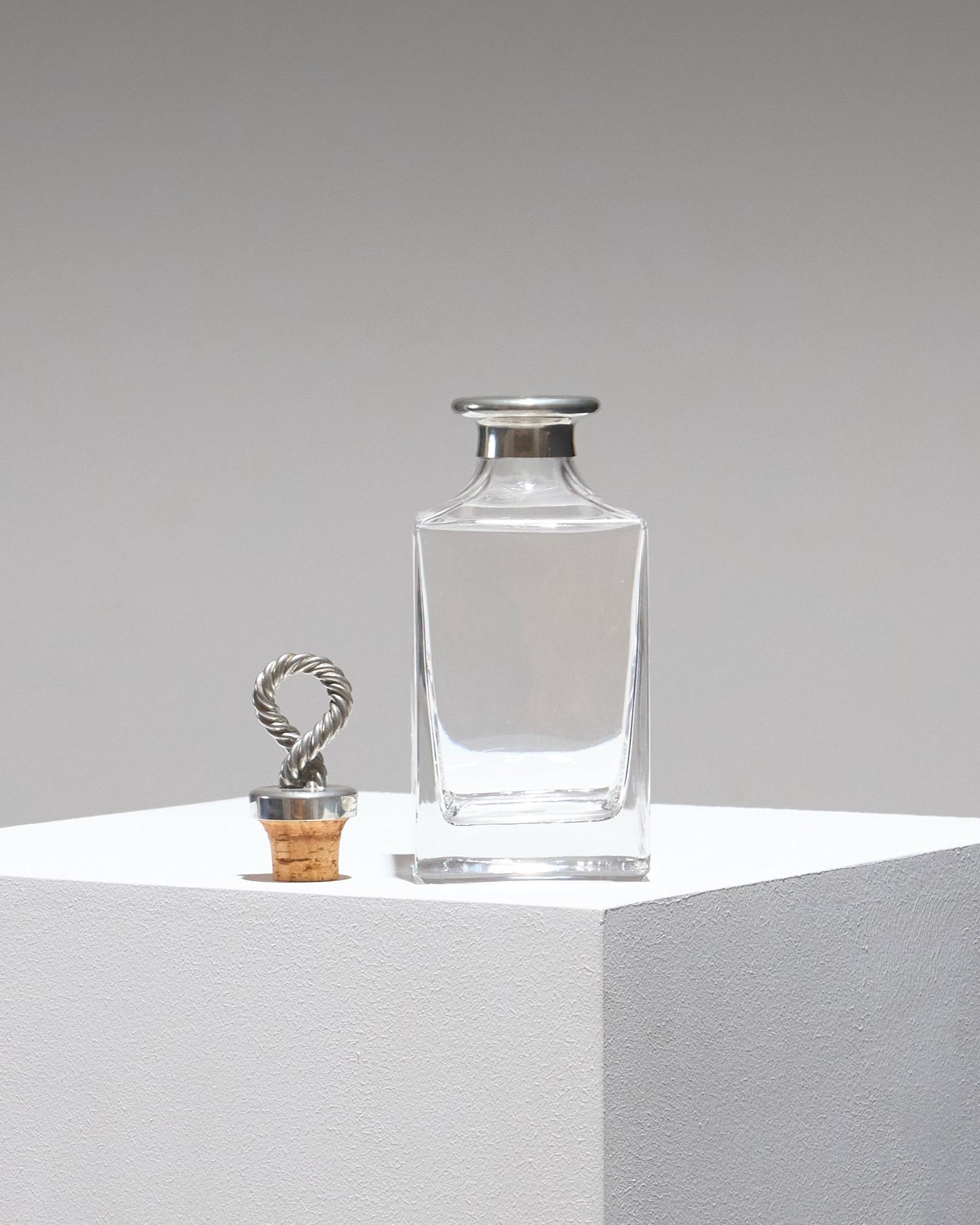 Carafe carrée en verre, bouchon en étain de style corde marine. Fabrication française par Les Étains du Manoir dans les années 1960. Très bon état.