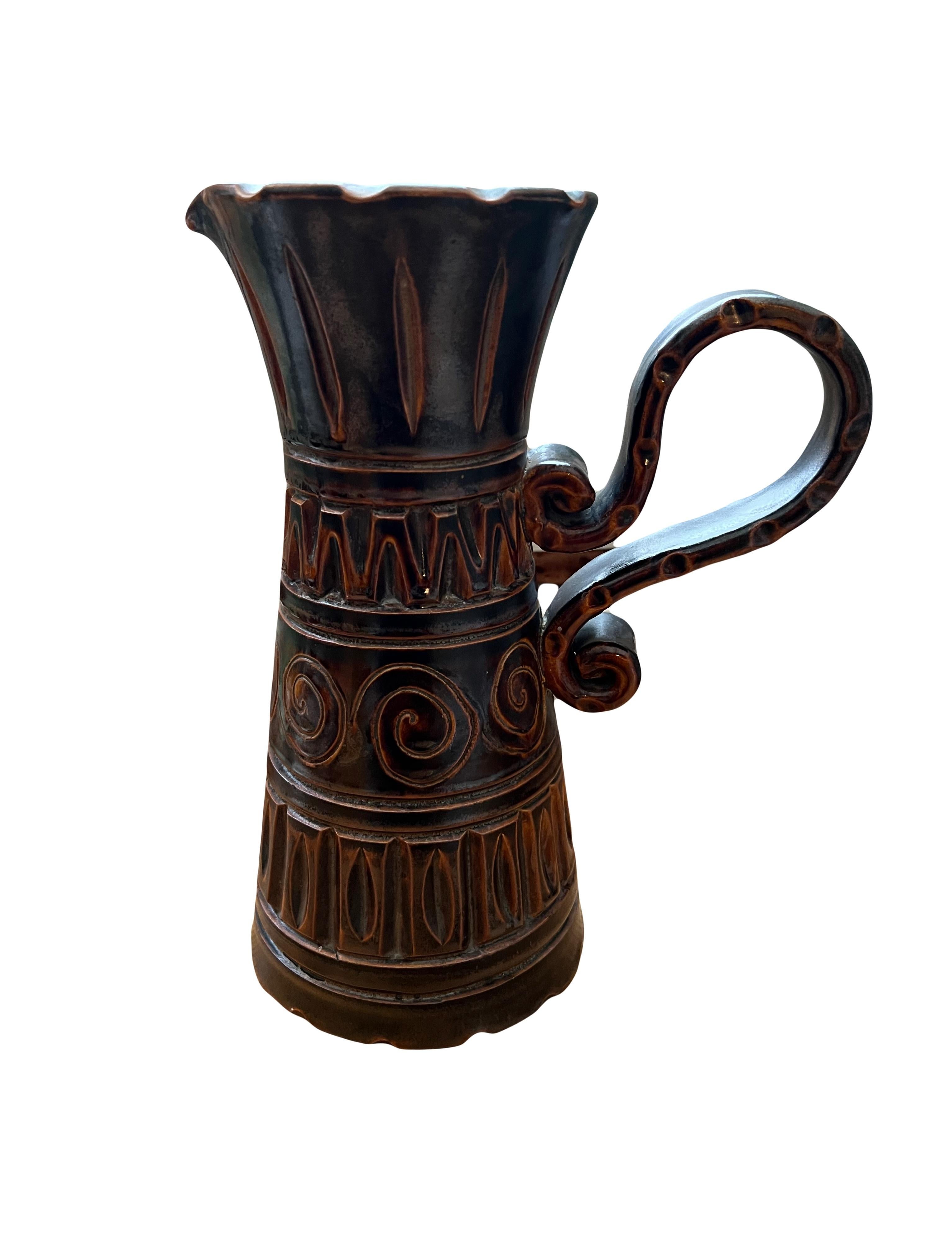 Orangeade Set by Huguette and Marius Bessone
A rare creation by the couple.

Pitcher set with 6 glasses in glazed brown ceramic featuring a rich incised graphic design inspired by tribal motifs, characteristic of the work of this artist couple. In