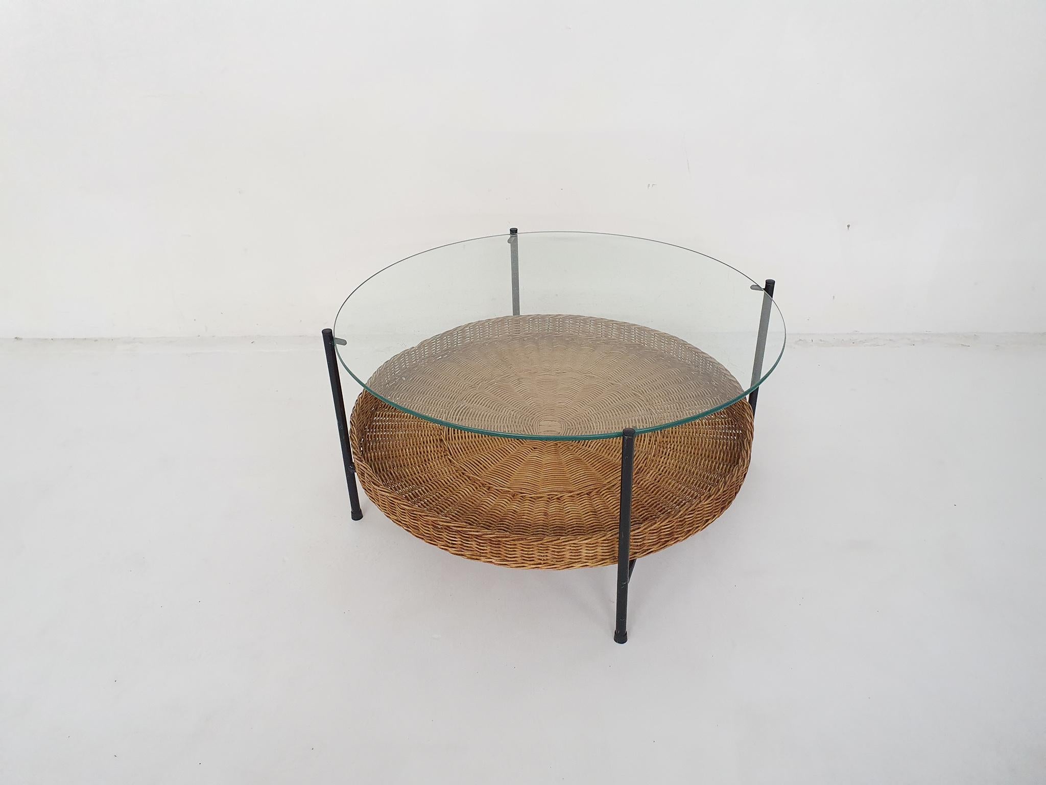 Black metal frame and rattan woven basket for magazines. Glass top has some scratches.