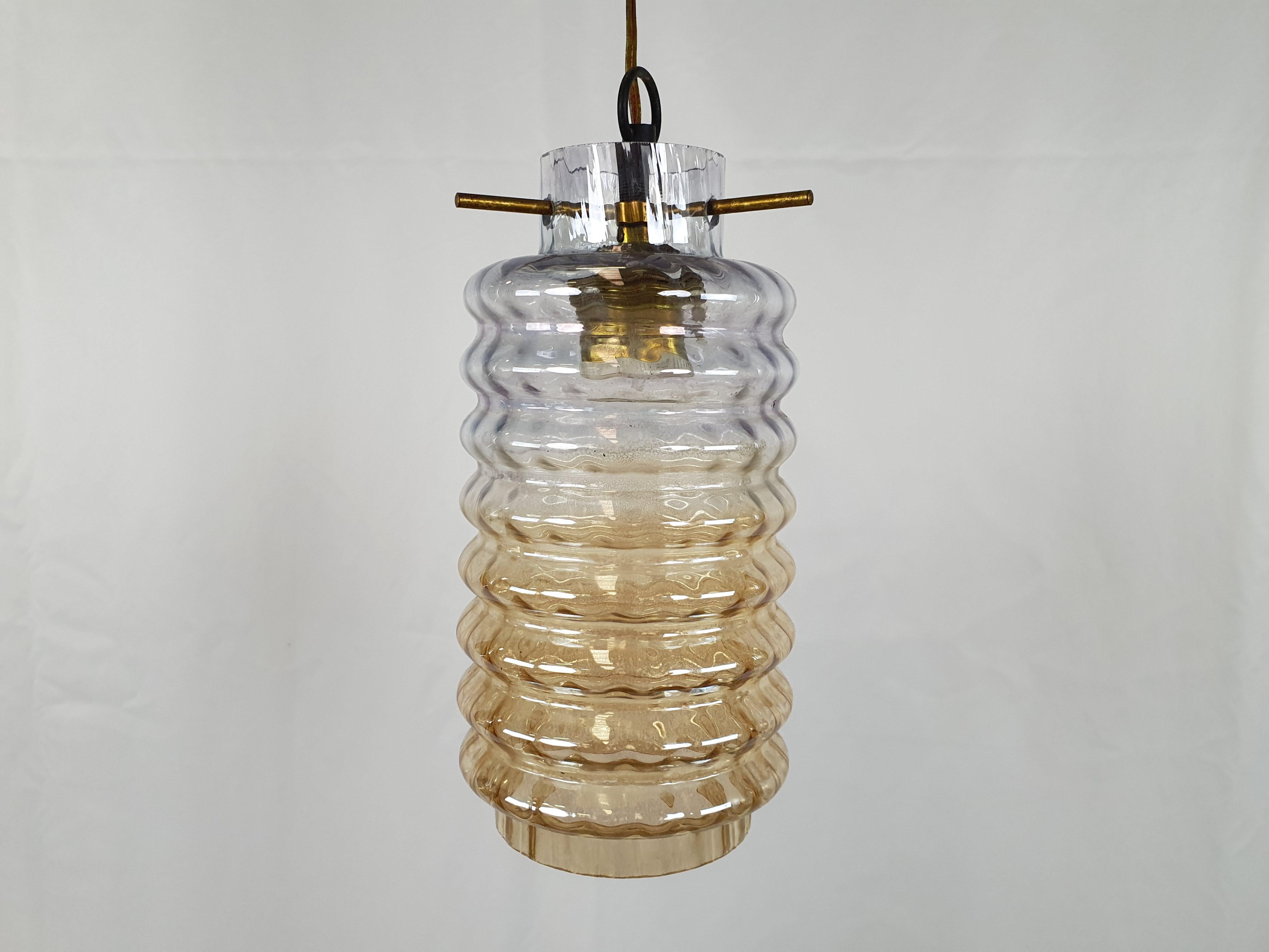 Compact tubular glass and smoked glass chandelier, Italian production in the 1970s.

Structure locked to the main support by three small unscrewable brass pins for bulb replacement.

Has normal signs of wear consistent with age and use. We