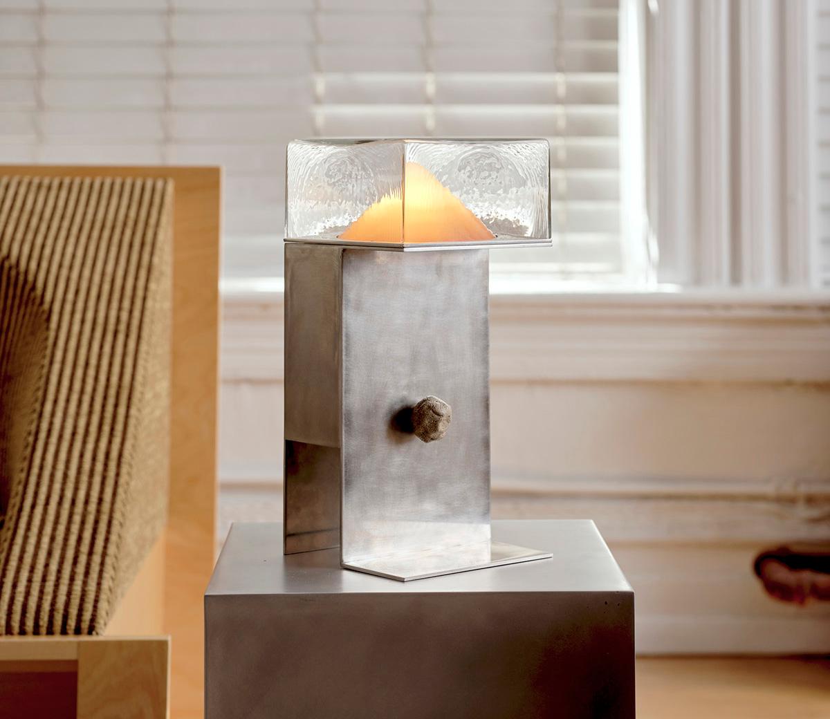 Delicate hand-blown glass and patinated steel combine to striking effect in this atmospheric table lamp that sets the mood with an alluring soft glow. The layered, mold-blown glass has been handcrafted to create a distinct effect to diffuse light.