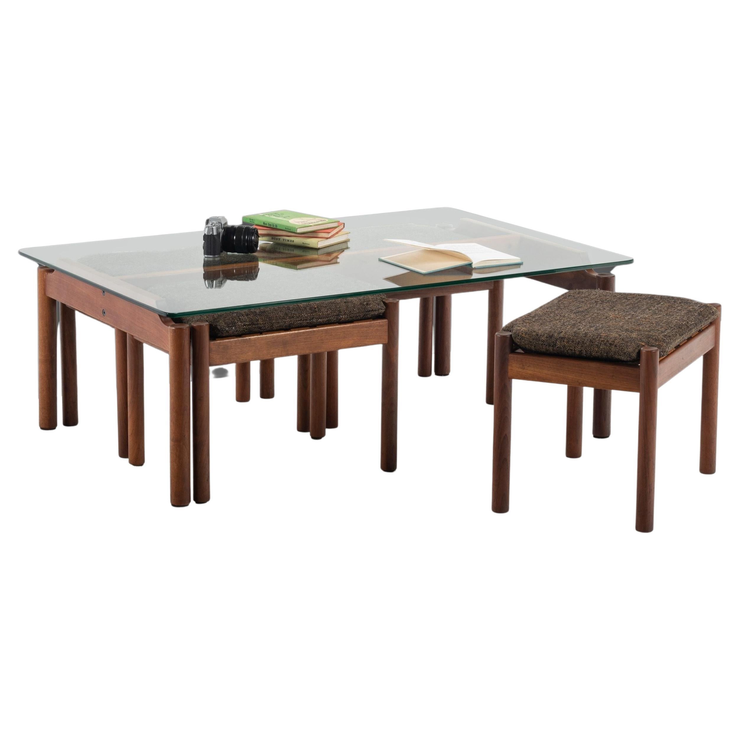 As functional as it is aesthetically pleasing this coffee table with matching nesting stools is perfect for collectors and designers looking to get the most out of a small-sized piece. Constructed of solid teak, a large thick-cut glass top and
