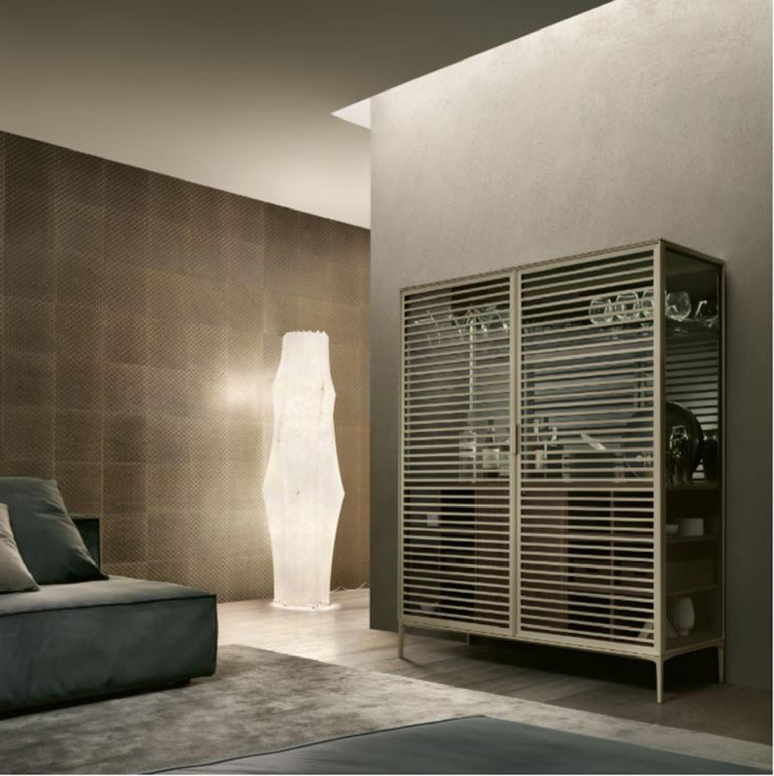 Le meuble de bar Alambra, conçu par Giuseppe Bavuso, est une version bar du meuble standard en verre et en bois de noyer. Il est équipé d'un réfrigérateur interne, de compartiments ouverts et d'une porte en noyer, d'un plateau et d'une poignée en