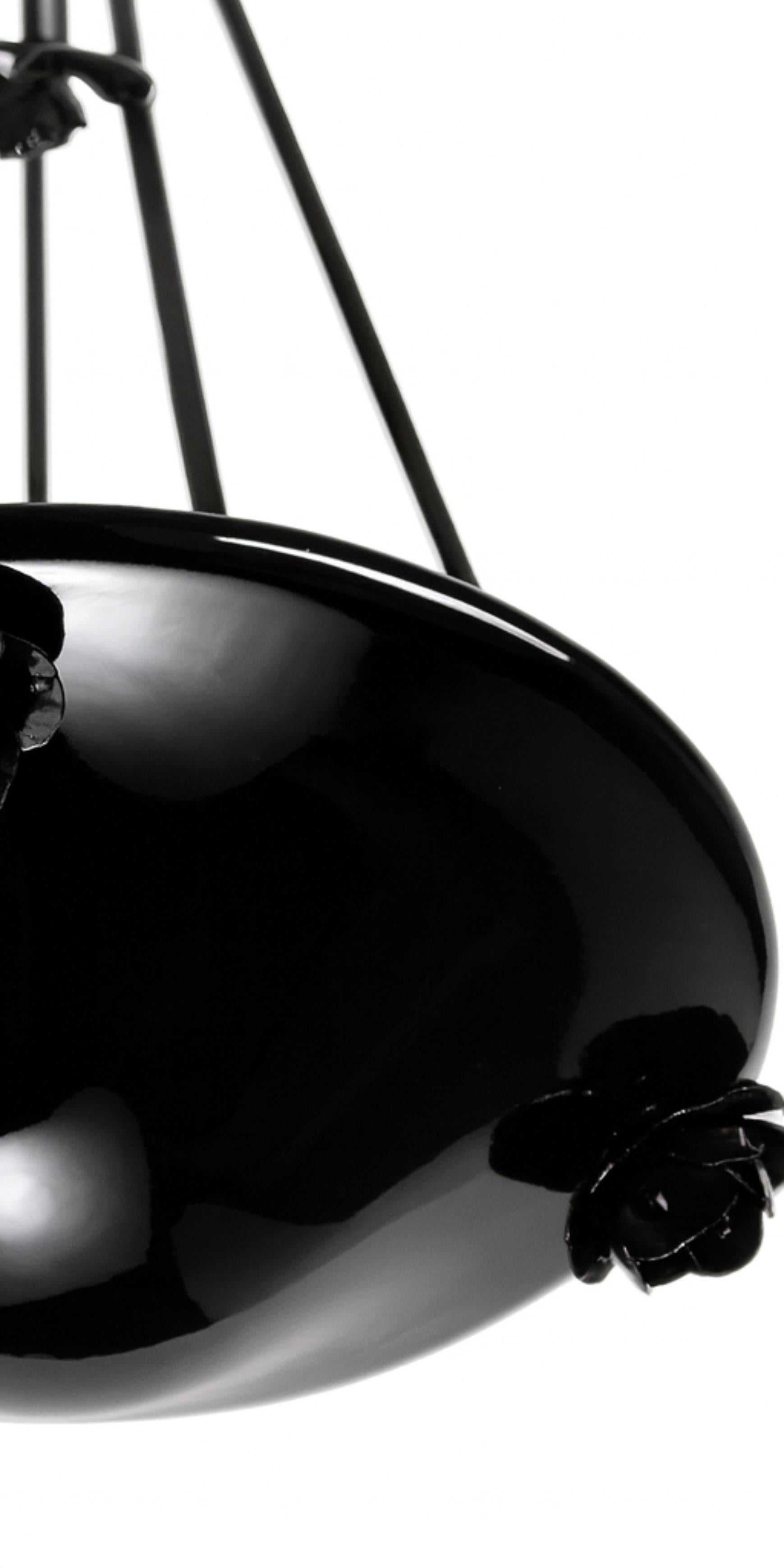 Ce plafonnier Art nouveau français du début du XXe siècle en laque noire, dans le style du verre de Nancy, est monté sur un cadre en fer forgé avec des motifs floraux décoratifs.
Le verre présente des caractéristiques typiques de la production Art