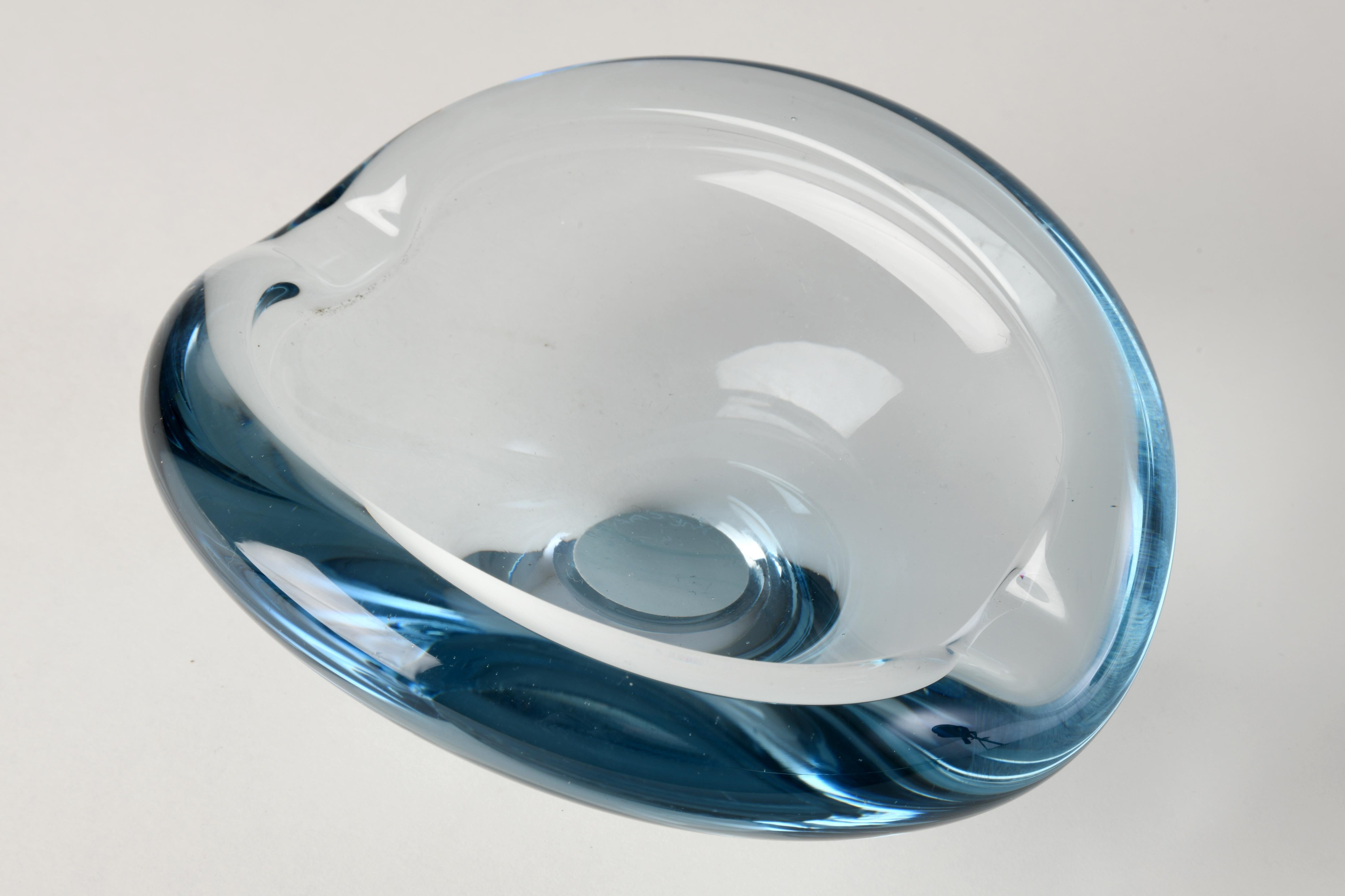 Blue glass ashtray designed by Per Lutken for Holmegaard in Denmark in the 1960s. This piece of glassware has beautiful curves and can also be used as a trinket dish. Slight signs of wear. Per Lutken (1916-1998) was a famous Danish glassmaker who