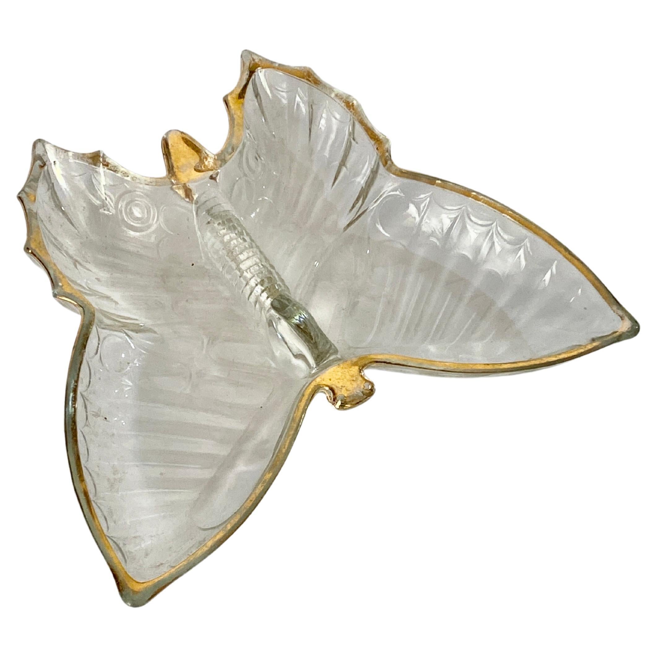 It is a glass ashtray, in the shape of a butterfly. It was made in France in the 80s. It has a gold edging that runs around the edge and the head of the ashtray.
