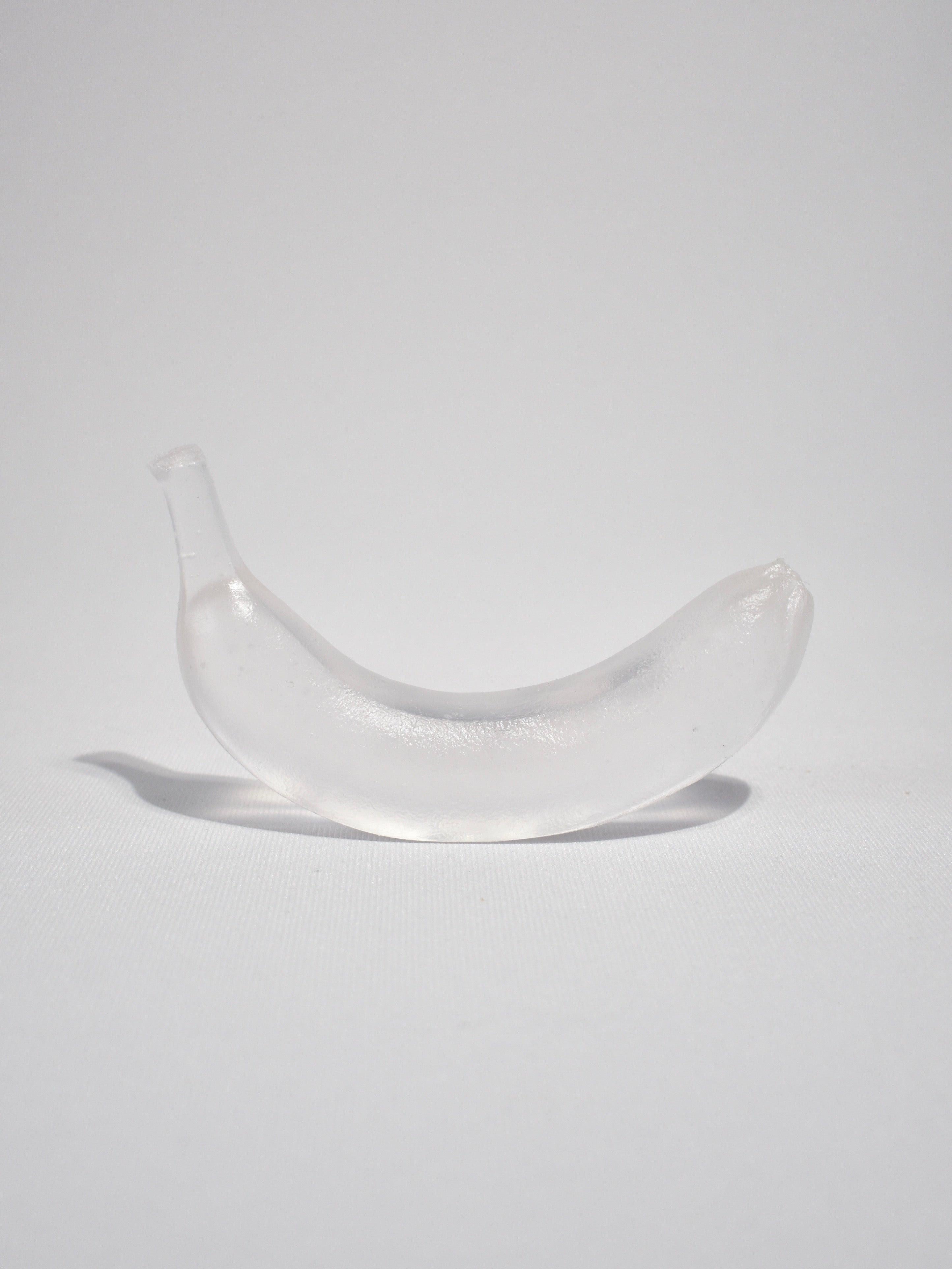 Casted glass banana in clear by Devon Made Glass Fruit inspired by blown glass fruit makers and collectors from the 1960's. The light playful approach to everyday fruit is contrasted with the heaviness of the crystal glass, a unique material that