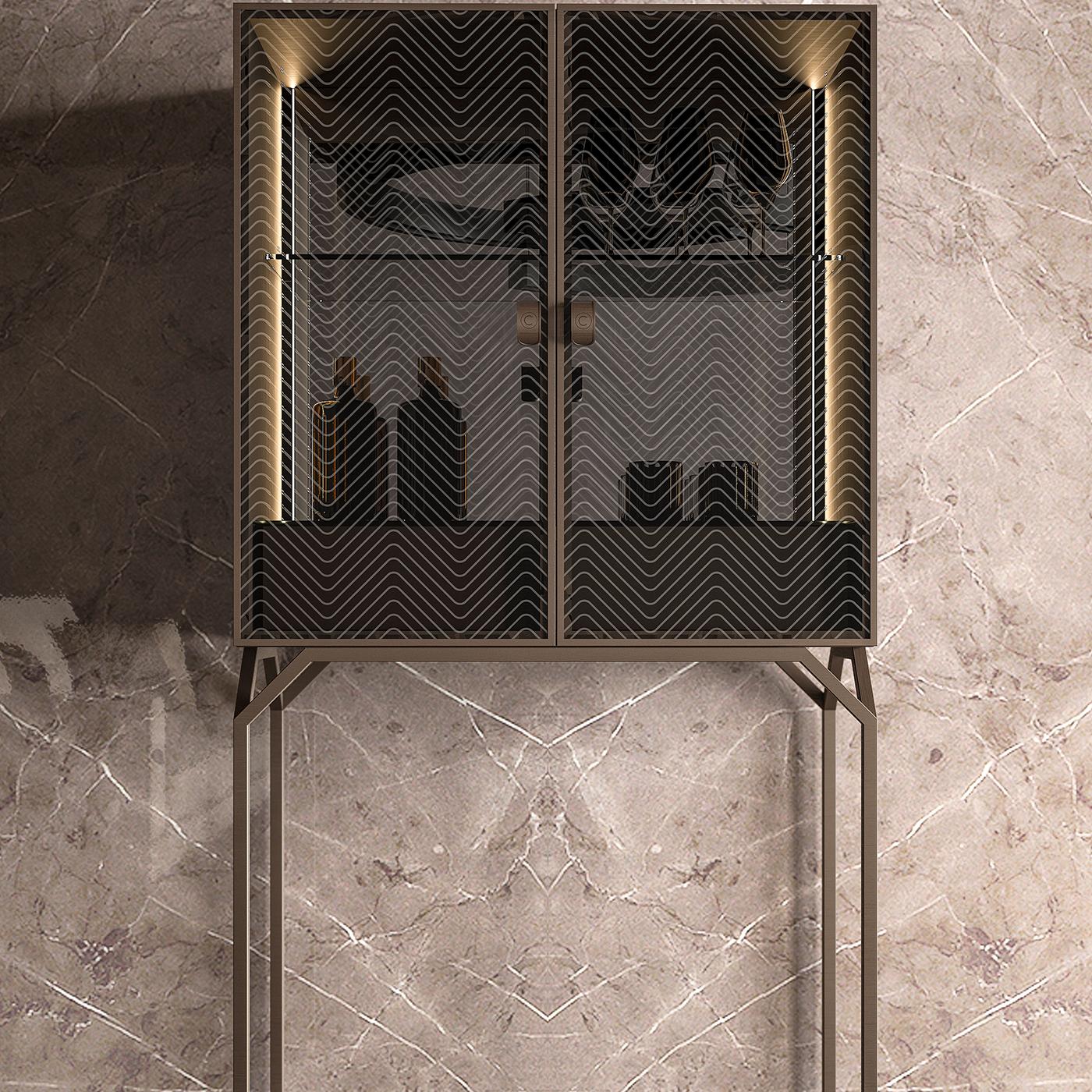 As if straight from the Great Gatsby, the glass bar cabinet features a Cipriani signature zig-zag engraving on its two front doors. On a slim metal base, the cabinet conceals two shelves and a spacious bottom area to display your best bottles with
