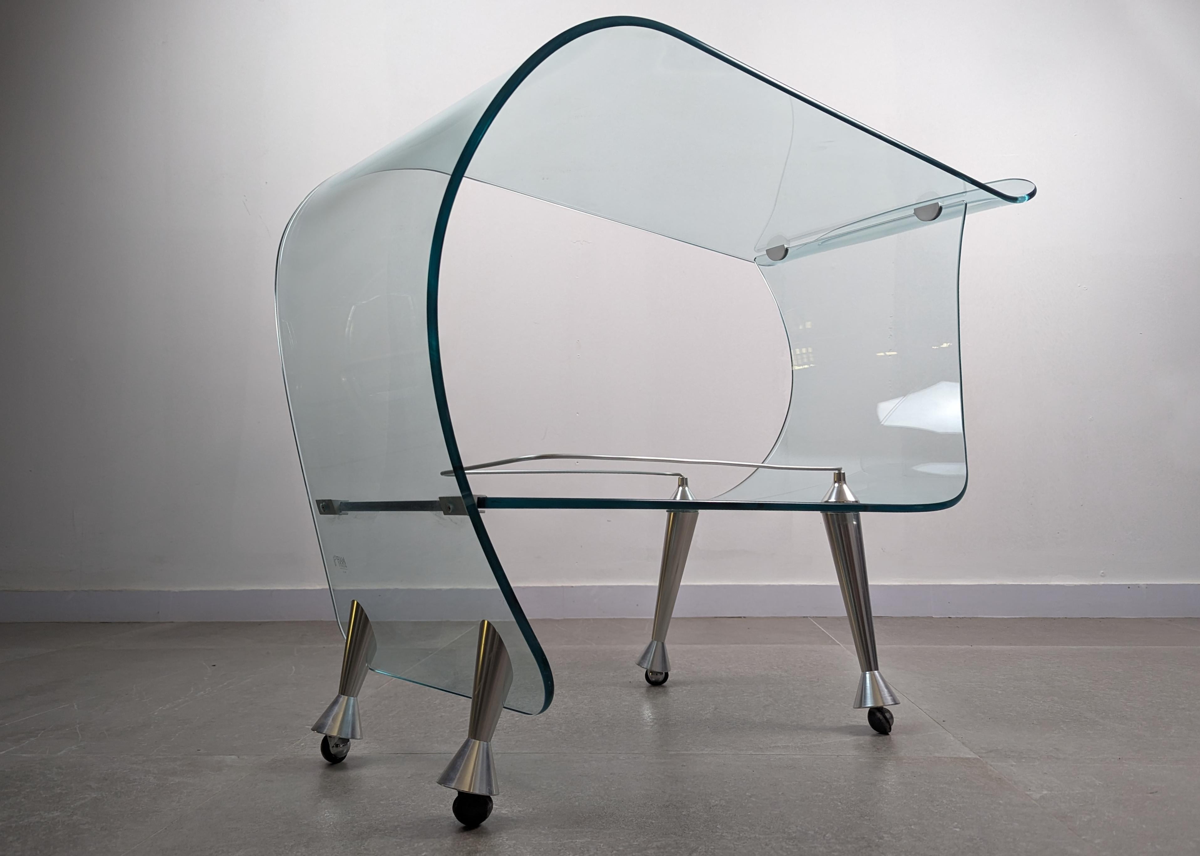 Spectacular bar service cart designed by the renowned Italian designer Massimo Iosa-Ghini exclusively for Fiam. This fantastic piece combines the elegance of curved glass with the stability of stainless steel. This vintage bar cart is a highly