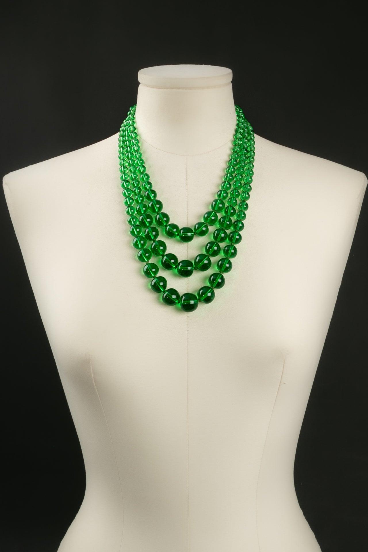 Three strings necklace composed of green glass beads with a plated silver clasp embellished with a re rhinestone.

Additional information:
Condition: Very good condition
Dimensions: Length: 47 cm (18.5