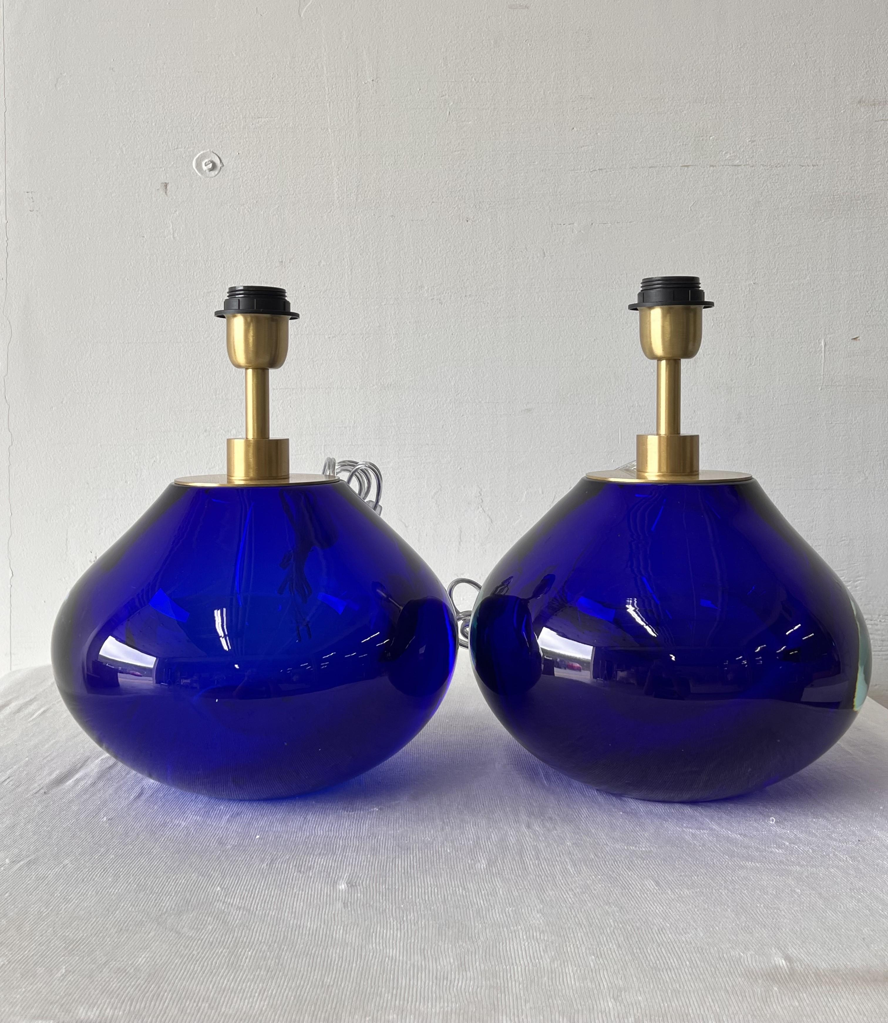 Lámparas de mesa de cristal de Murano azul firmadas por Alberto Dona. Hecho a mano en Murano, Italia.

Estas lámparas tienen un elegante color azul oscuro con elegantes vástagos de latón que añaden un toque de sofisticación. Perfecto para añadir un