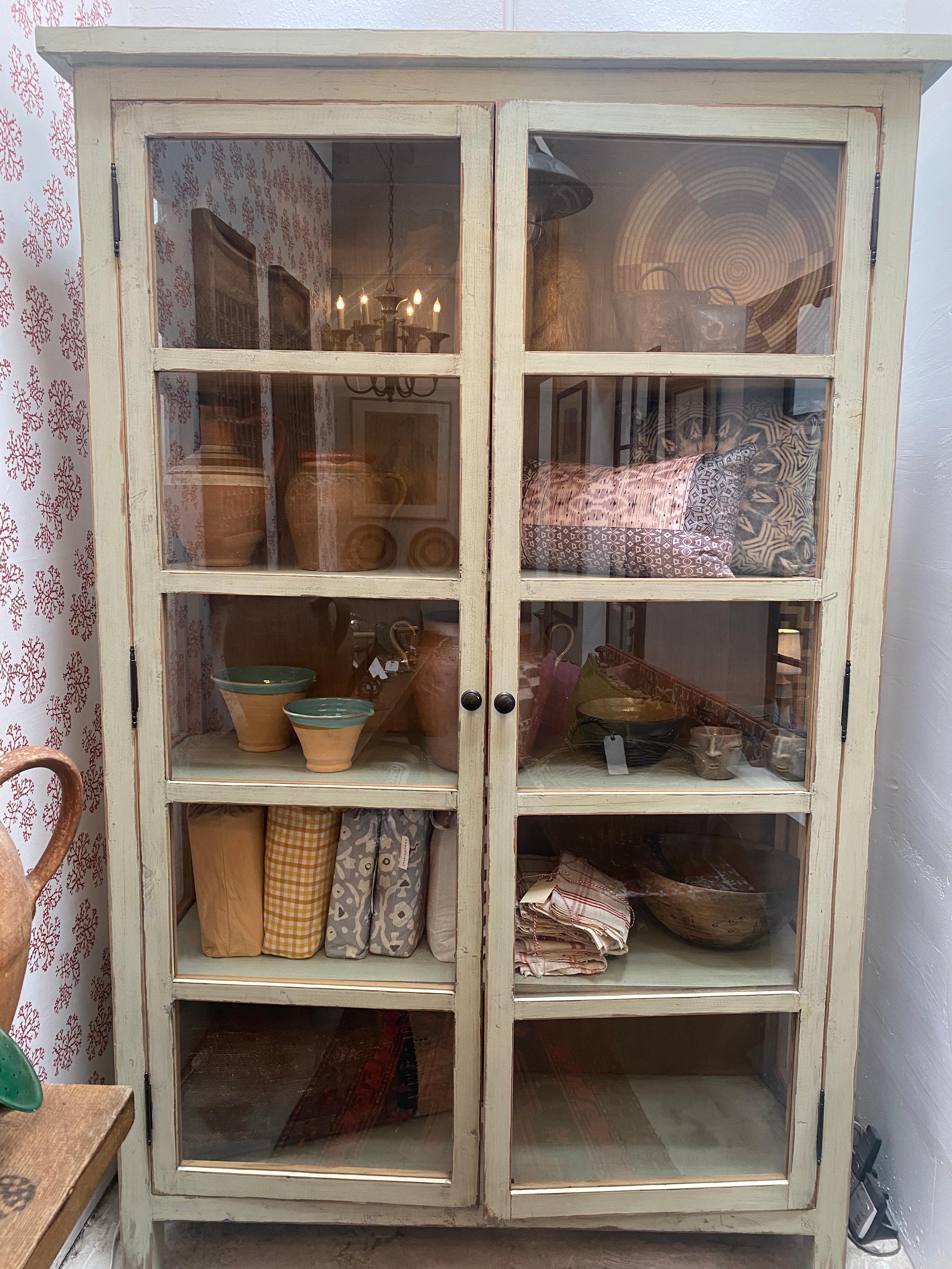 Tall, shelved display cabinet with glass windowed front and sides. Lightly distressed Sage Green finish.
     