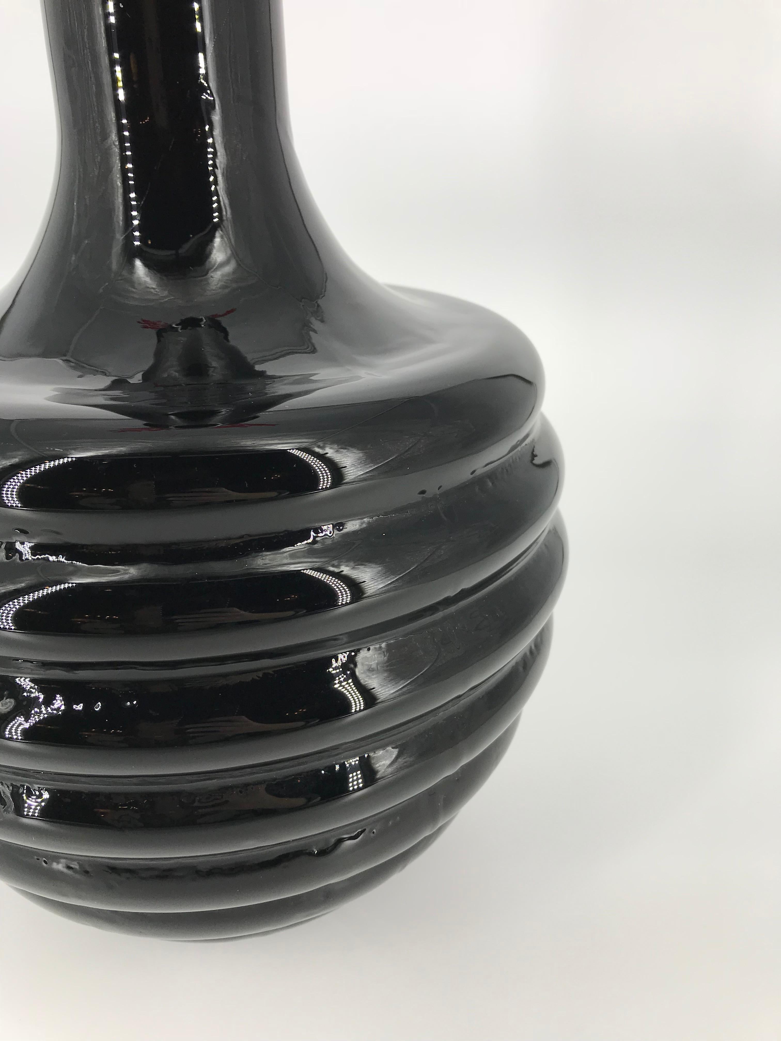 Black Murano glass  jar e with a bottle shape and a red coral stopper.
Made in Italy, Murano city
2000's circa