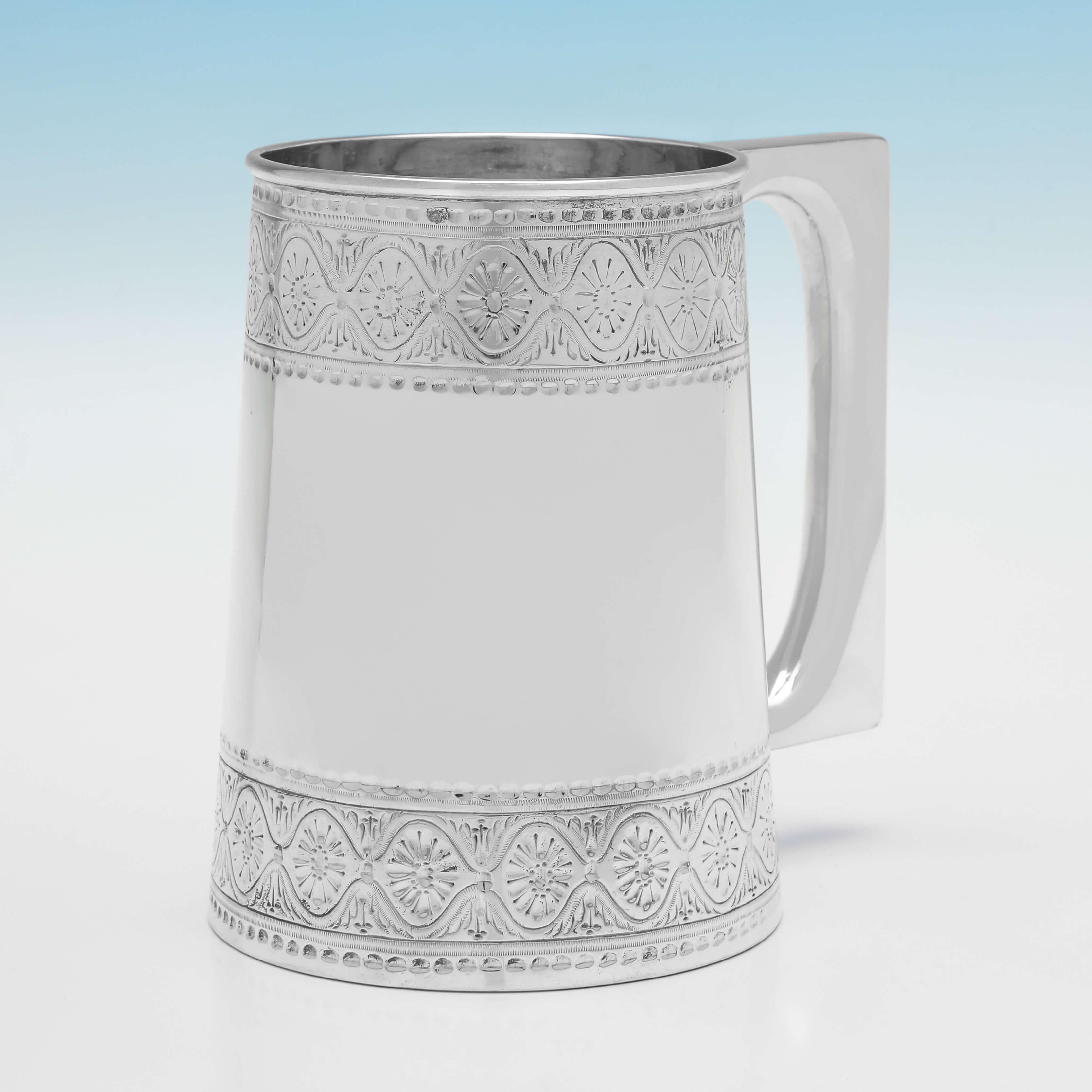 Hallmarked in Sheffield in 1891 by Gibson & Langman, this handsome, victorian, antique, sterling silver tankard, is straight sided, and features a glass bottom, and engraved bands to the rim and base.

The mug measures: 4.75