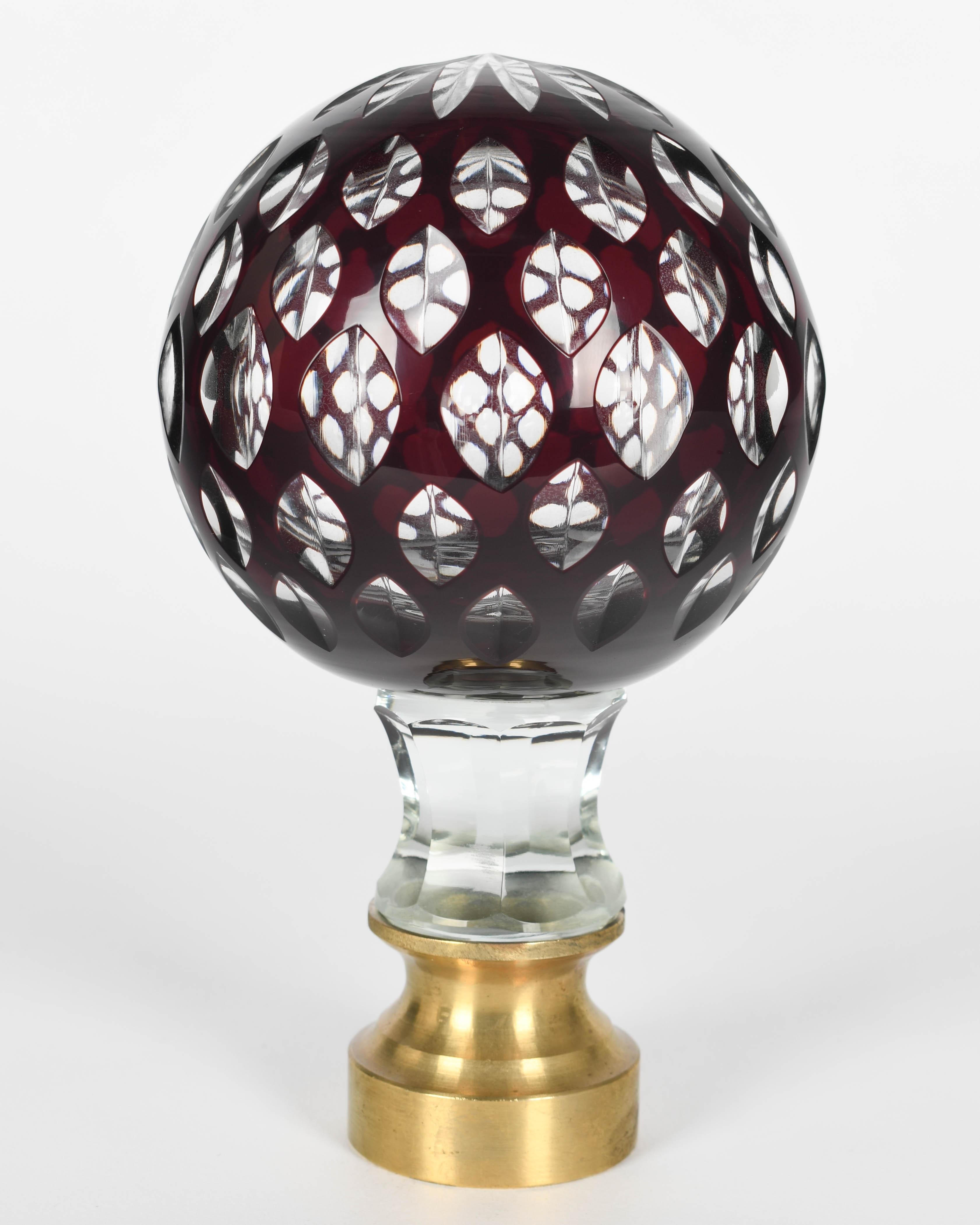 An early 20th century French cut glass boules d'escalier, or newel post finial. Clear glass with an outer layer of deep ruby red and a multi-cut star at the top. These wonderful finials were used as decorative elements at the bottom of a staircase