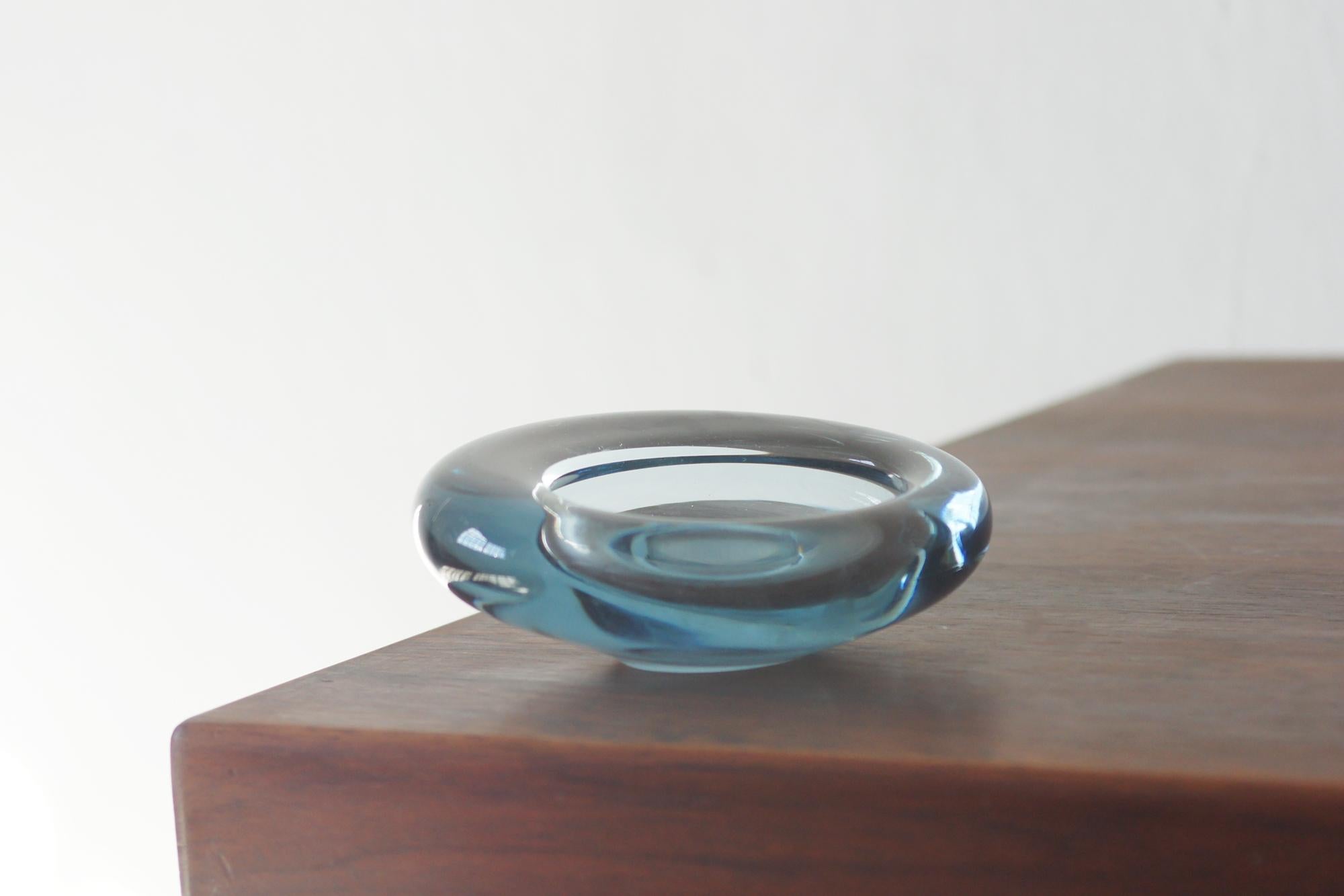 La coppa di vetro disegnata da Per Lütken per Holmegaard è uno degli esempi più riconoscibili di vetro artistico danese del XX secolo. Lütken, capo designer della rinomata vetreria per più di quarant'anni, ha creato vasi che combinano la sensualità