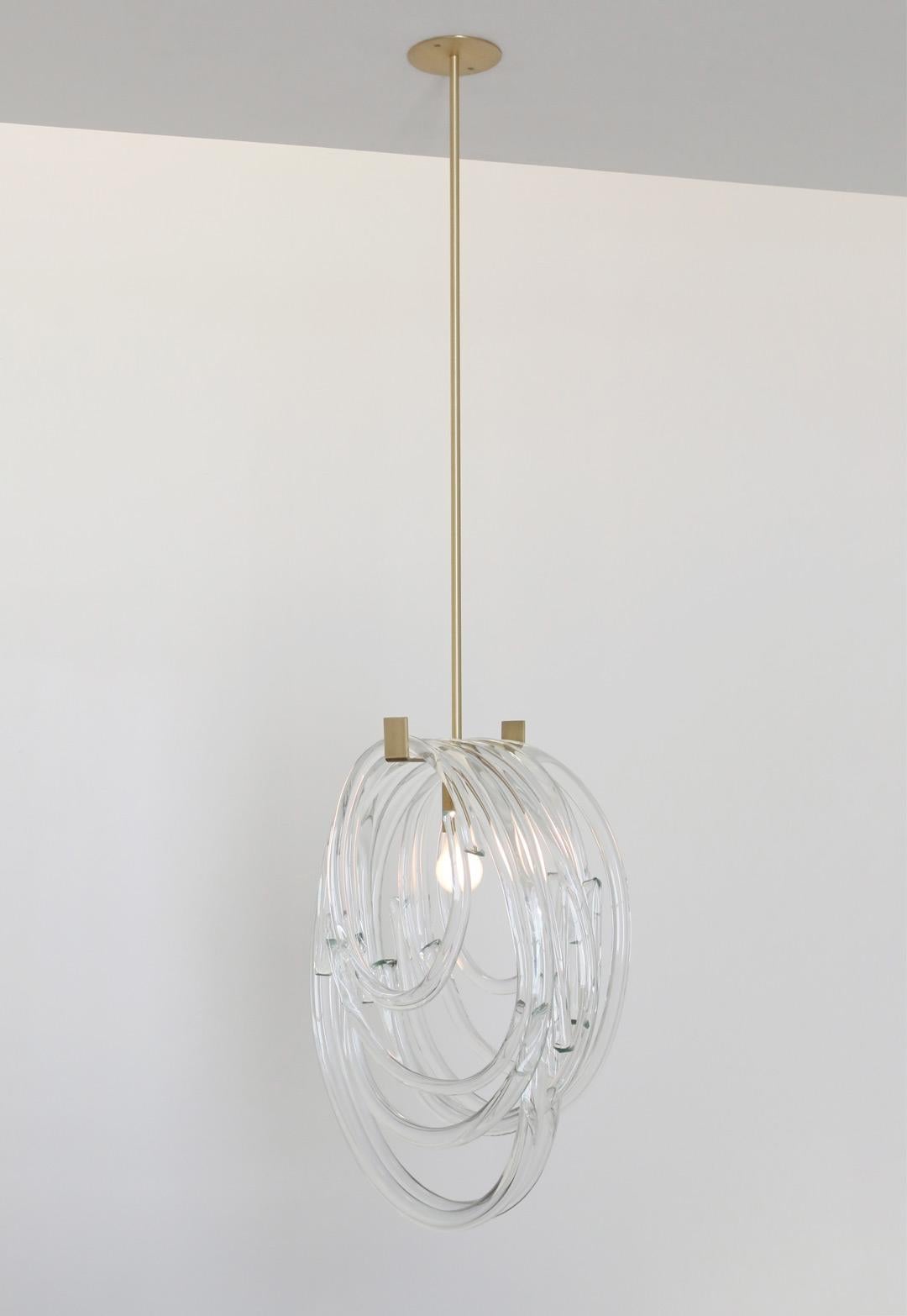 Solid loops of handblown glass serve as a shade for this sculptural pendant. The glass loops come in different sizes, showcasing the amazing quality and clarity of the Czech glass. Each loop is made by hand, so each is unique and slightly different,