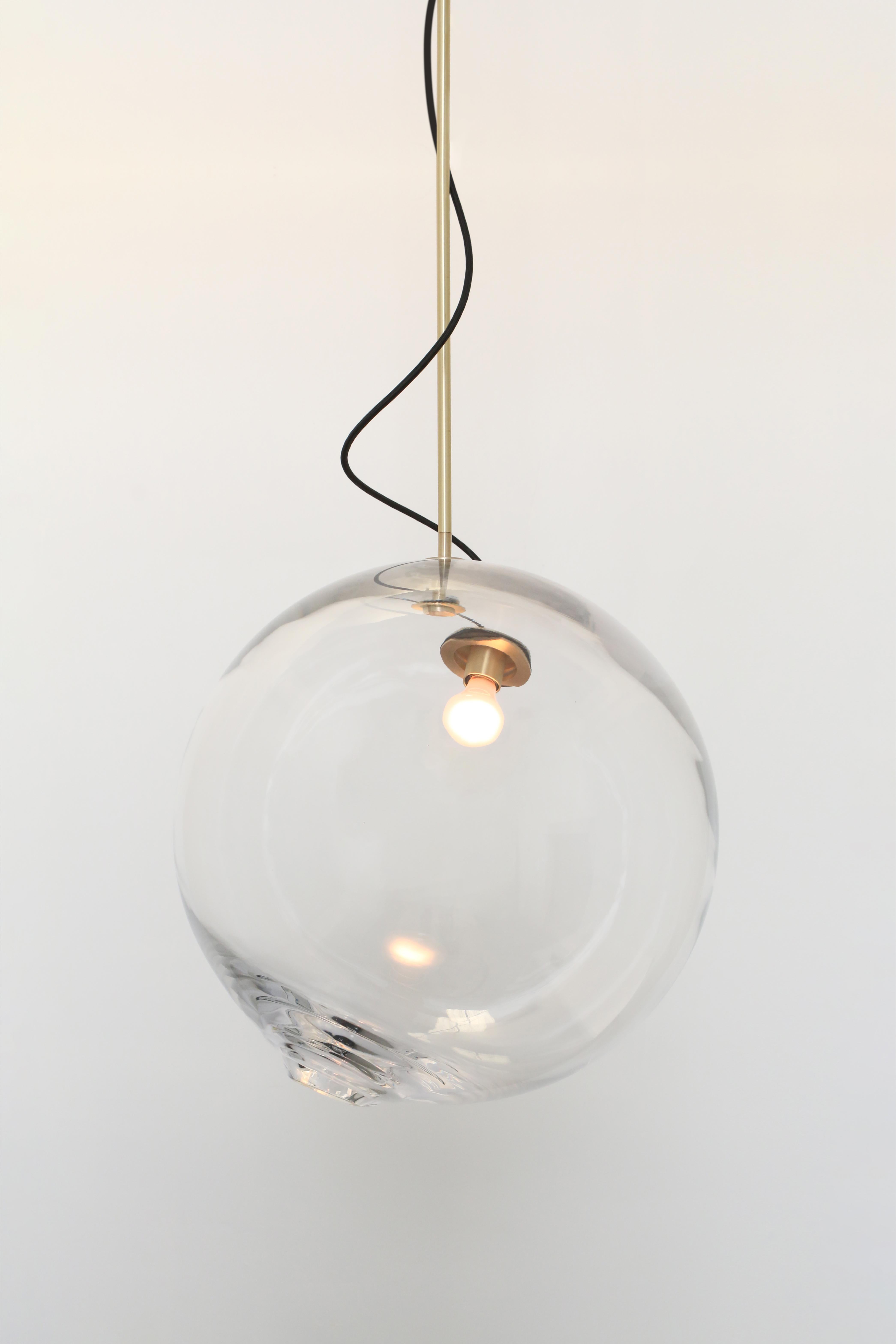 Large spheres of handblown Czech glass suspended on rigid brass stems. Two glass sizes available. A custom brass socket assembly through one side holds the light bulb and is connected to the canopy at the ceiling with a length of exposed
