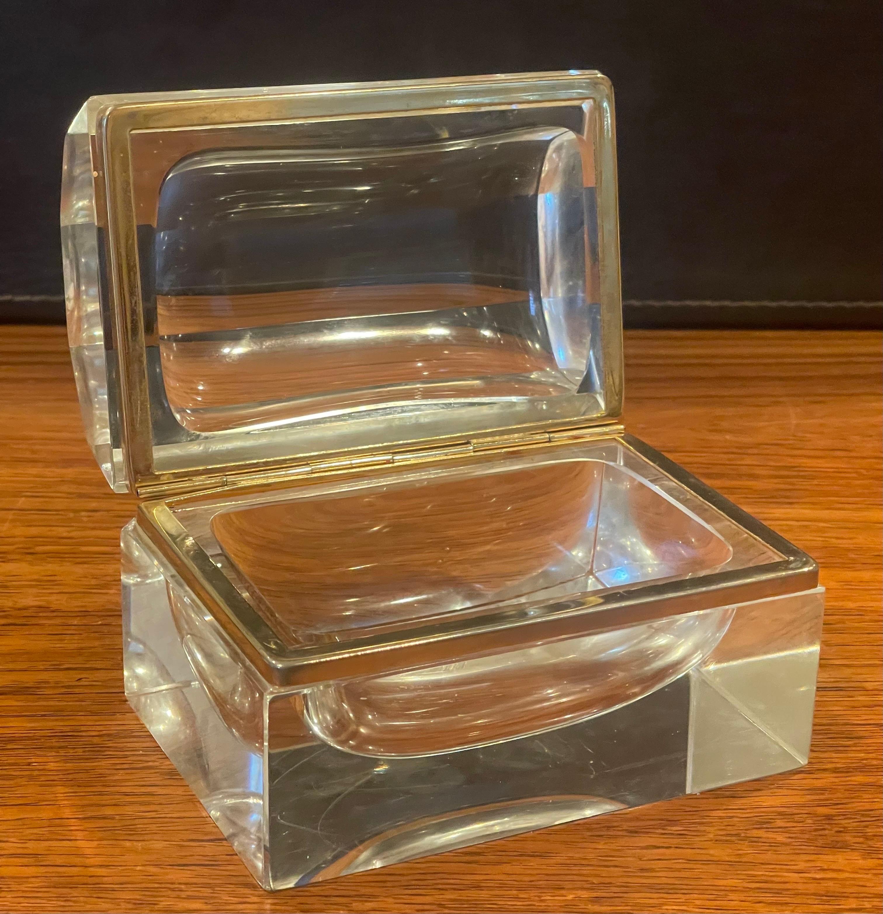 A fabulous glass and brass lidded trinket box, circa late 1960s..The box is made of a thick clear glass with bronze latch and trim. The set is in very good antique condition with no chips or cracks and measures 5.25