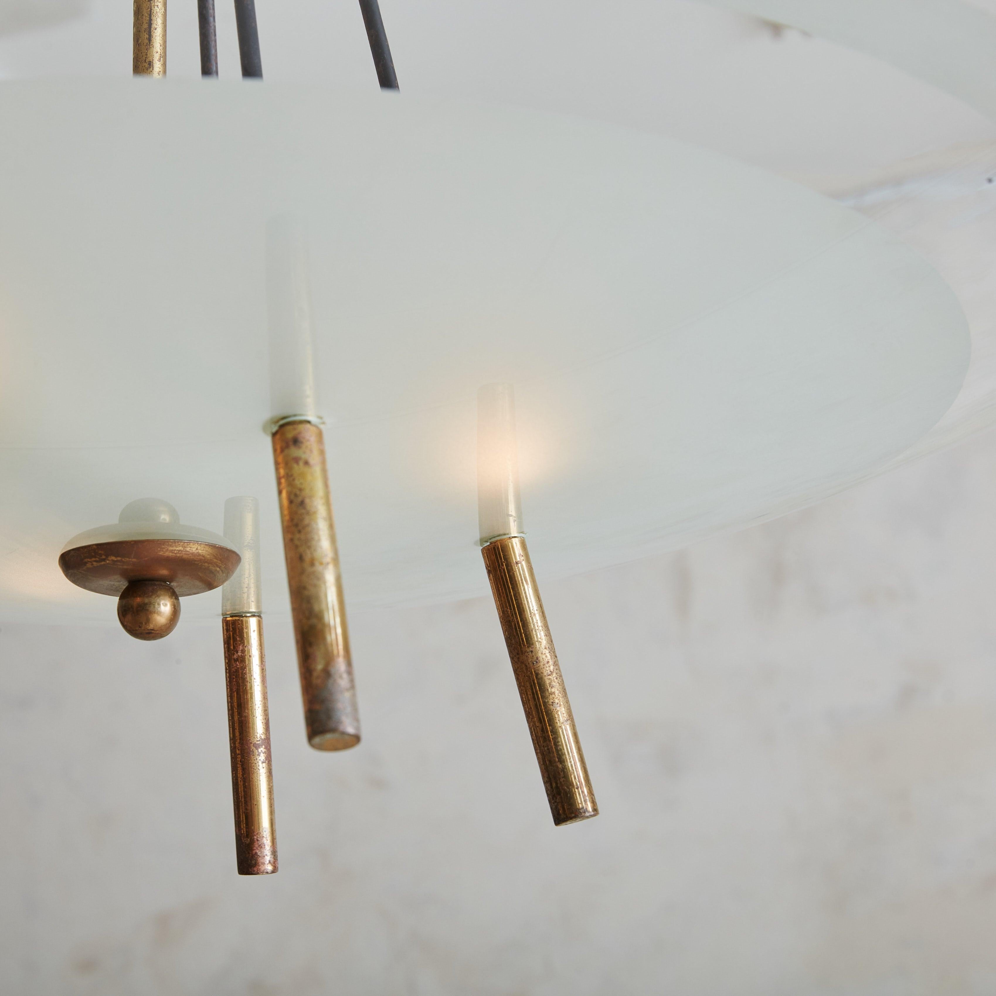 A stunning 1960s Italian pendant light featuring a partially frosted round glass shade with a subtle aqua-hued rim. The Sputnik silhouette is composed of a central patinated brass stem that radiates six slender rods, effortlessly supporting the