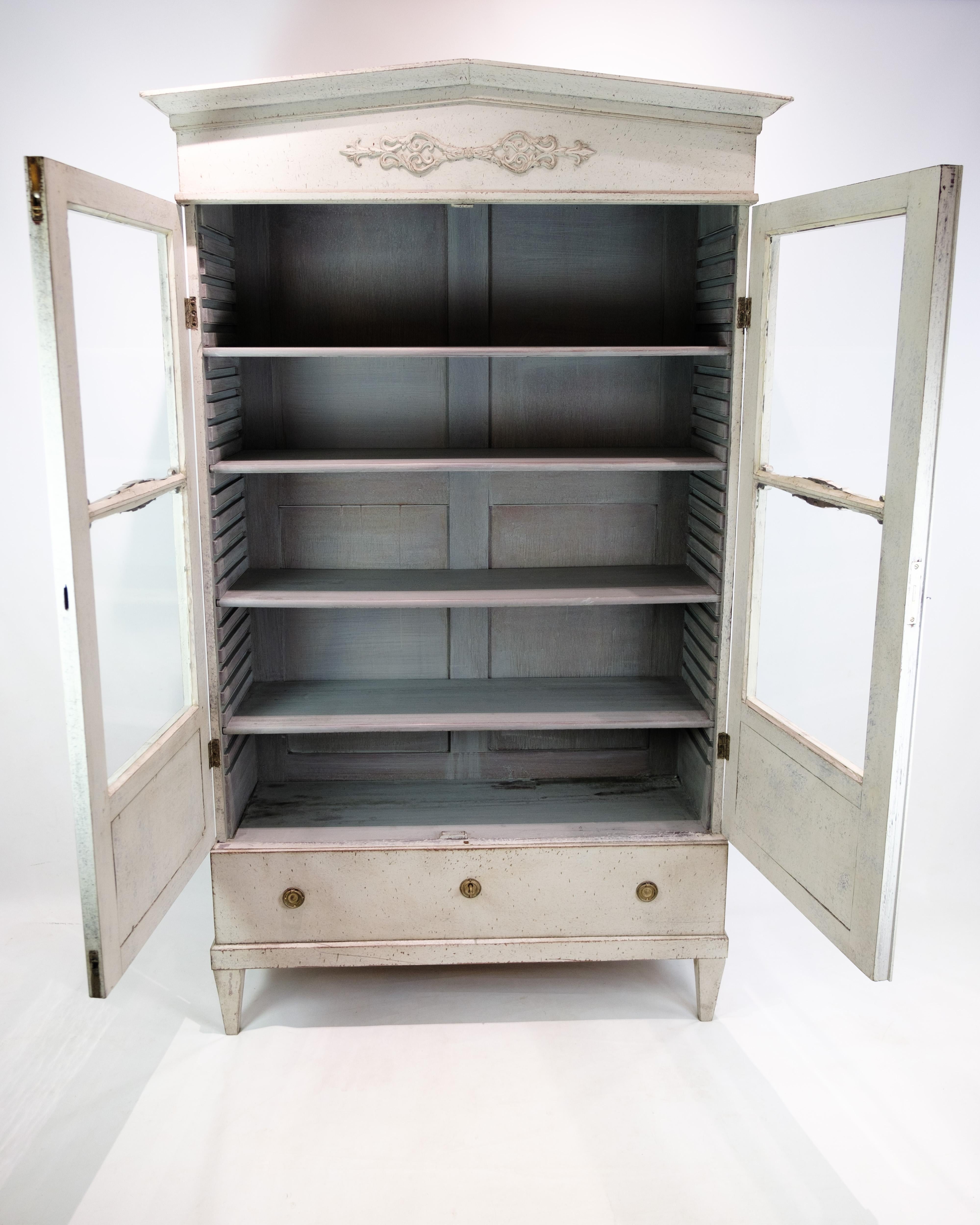 Glasvitrine mit schönem grau gemaltem Dekor aus der Gustavianischen Zeit 1810. Der Schrank hat eine große Schublade am Boden und 4 große Einlegeböden mit viel Stauraum. Der Schrank ist mit Messinggriffen und -schlössern verziert. Es ist ein sehr
