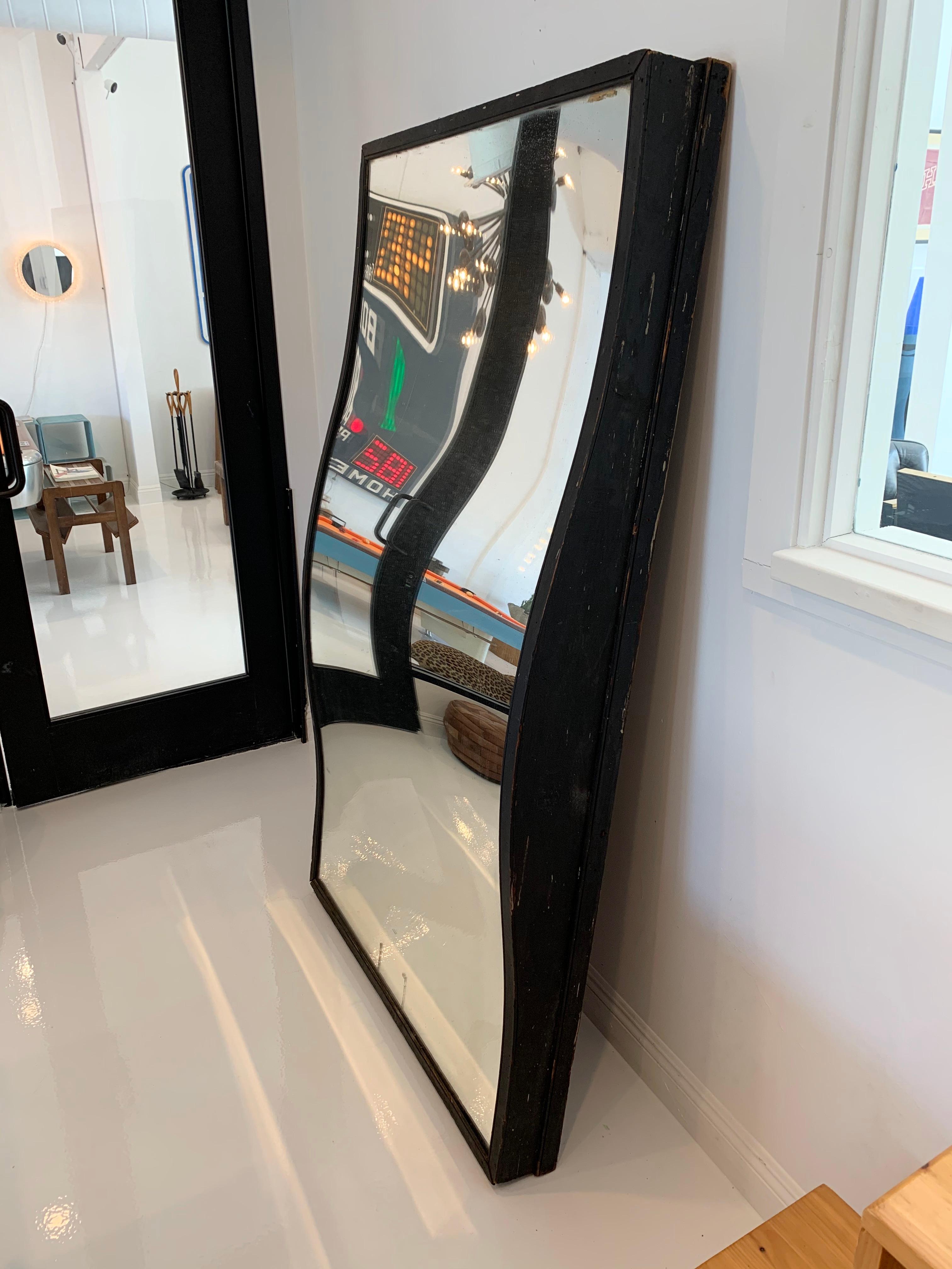 Massive carnival fun-house mirror. Unusually wide scale/frame. Wood frame with undulating glass. Great patina to glass, great vintage overall condition. Distorts the image depending on the distance from the mirror. Fun piece of wall art. 



