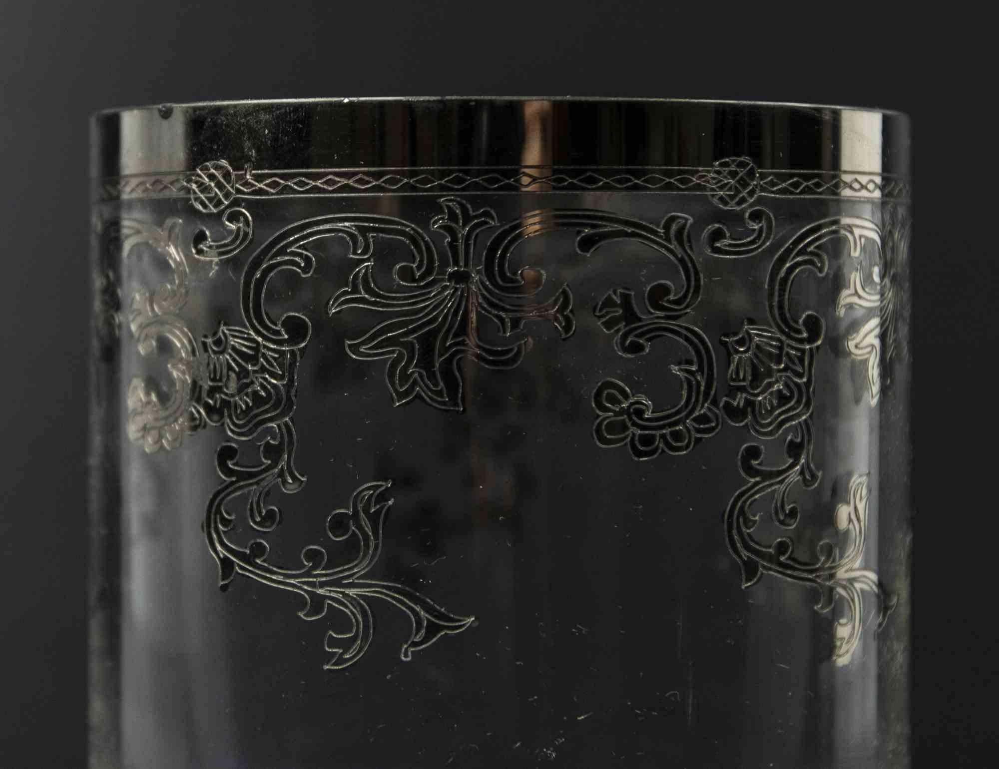 El centro de mesa de cristal es un original objeto decorativo realizado a mediados del siglo XX.

Un centro de mesa vintage totalmente realizado en cristal transparente con una decoración floral plateada en los bordes.

Un elegante centro de