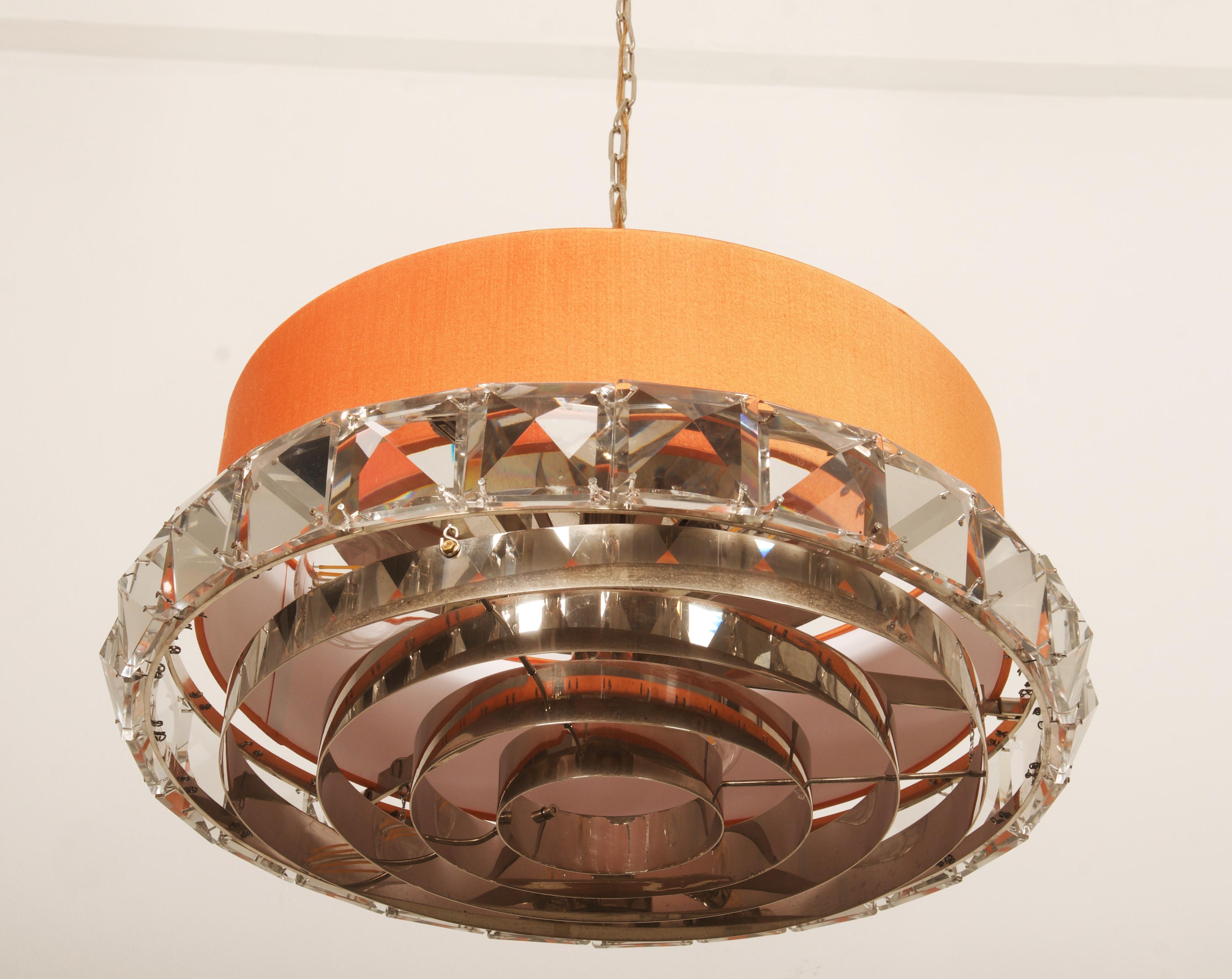 Struttura in ottone cromato con elementi in vetro e paralume in seta, dotata di 3 prese E27 fino a 60watt. Realizzato in Svezia negli anni '60 dalla vetreria Orrefors.