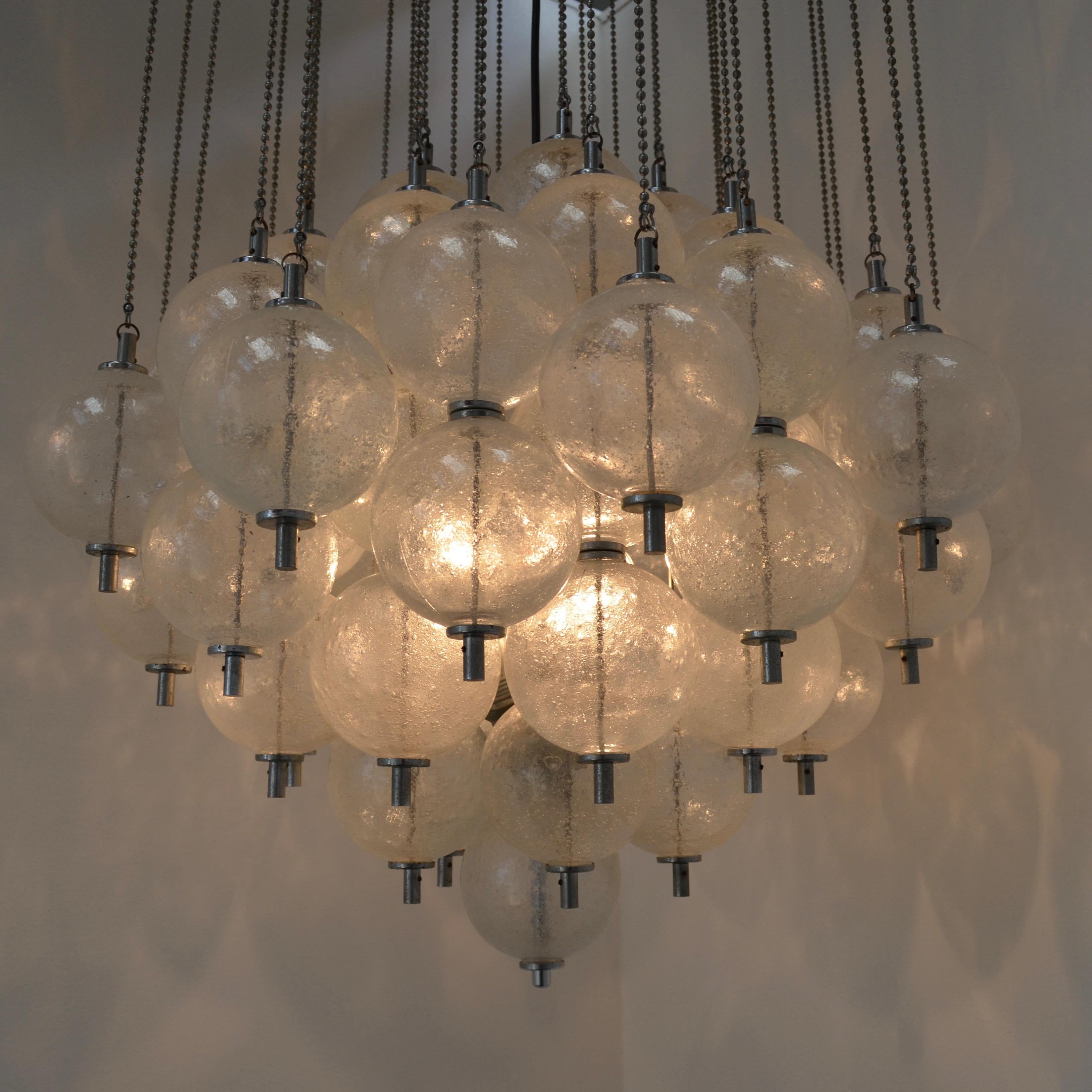 Model B1033 by RAAK Amsterdam also know as Sterrenbeeld (Zodiac) is a large chandelier with 71 volcanic glass spheres. Each sphere is hanging on a separate metal string. The three light bulbs which light up the spheres, are hidden between the 71