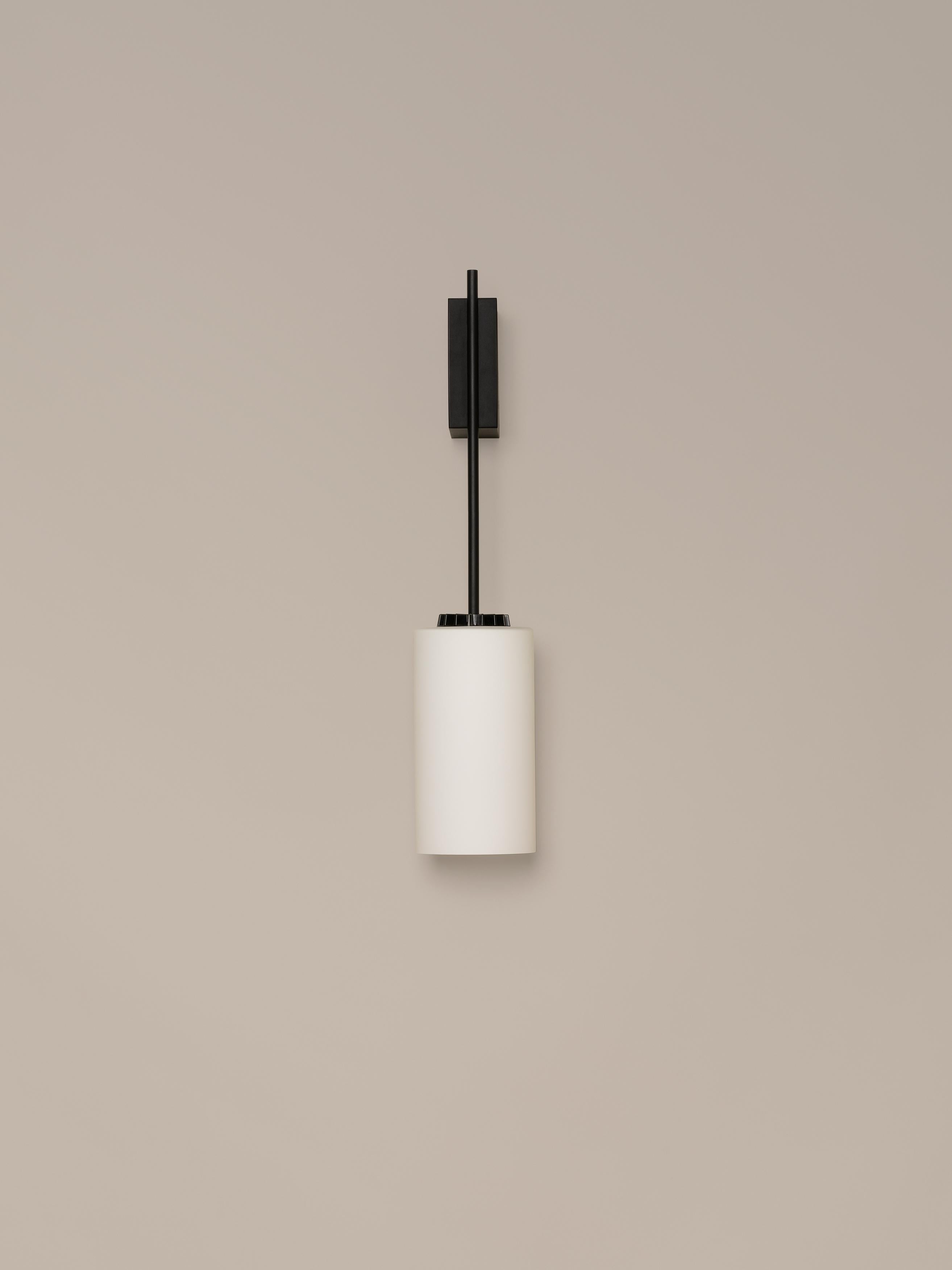 Glass cirio wall lamp by Antoni Arola
Dimensions: D 11 x W 14 x H 54 cm
Materials: metal, white opal glass.

The wall version of cirio allows the light to be placed at a closer scale to the user. This creates a succession of rhythms that, in